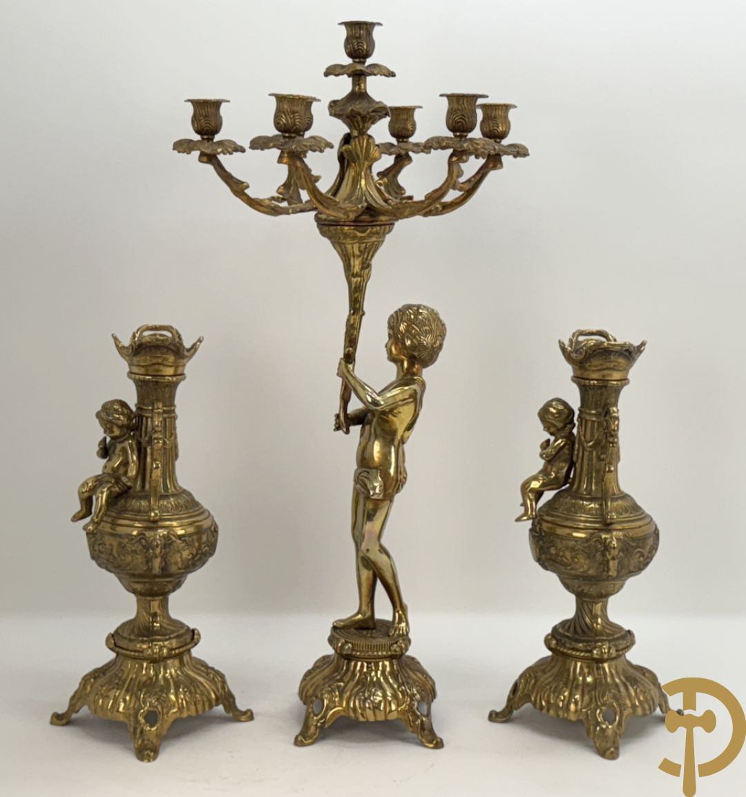 Paar koperen cassolettes bezet met ramskoppen dragende een cupido + koperen beeld van jongeman met zevenarmige kandelaar