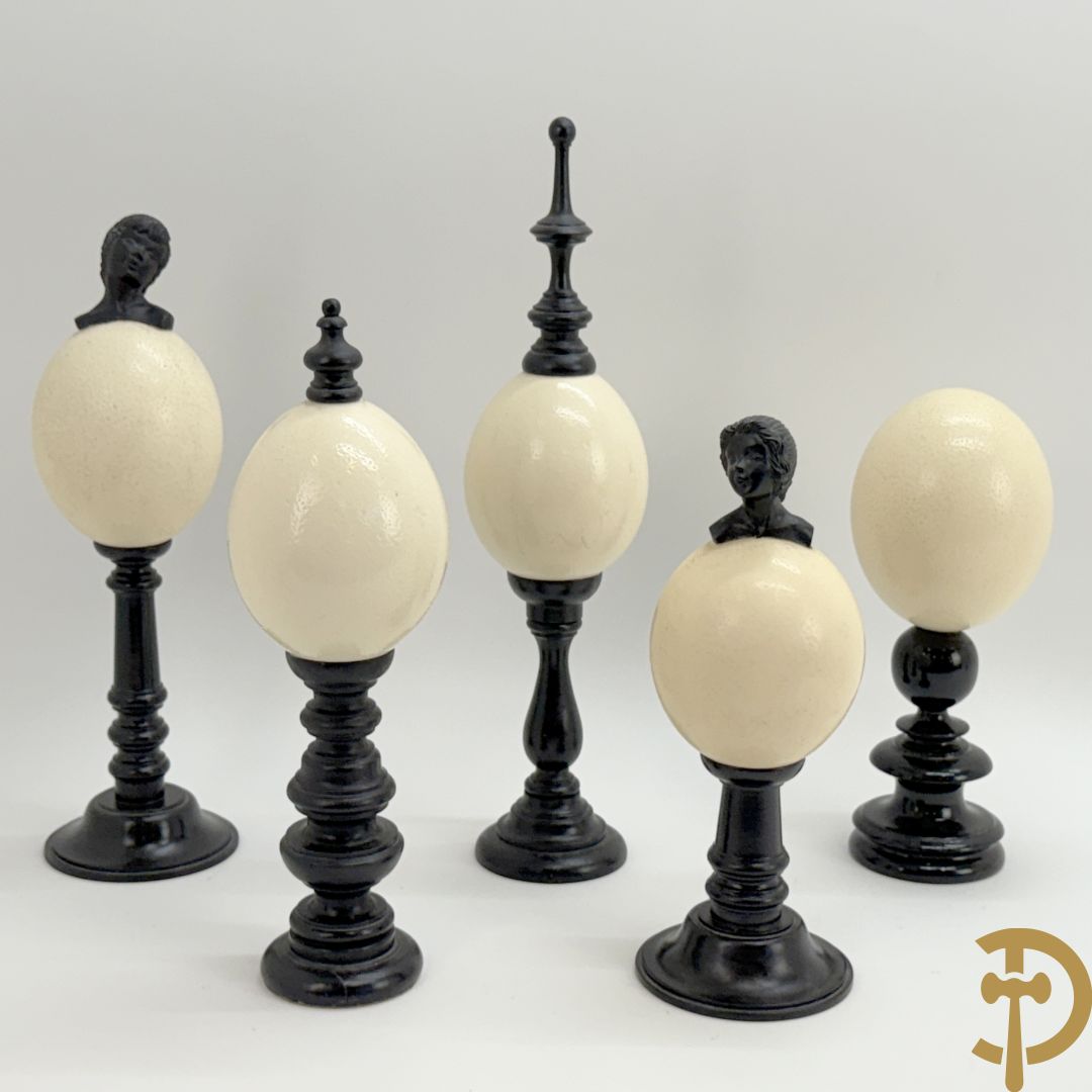 Vijf struisvogeleieren op zwart houten statief