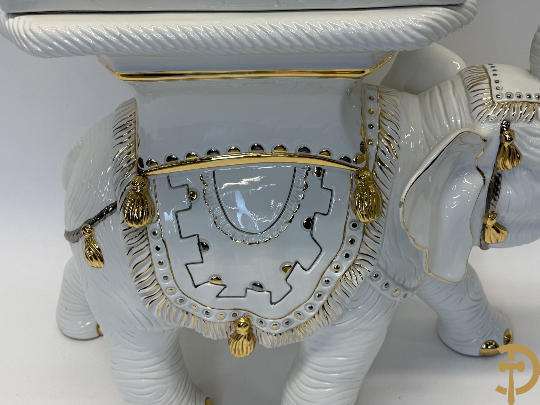 Porseleinen sierbeeld van olifant als staander met daarboven jongeman met bloemencachepot