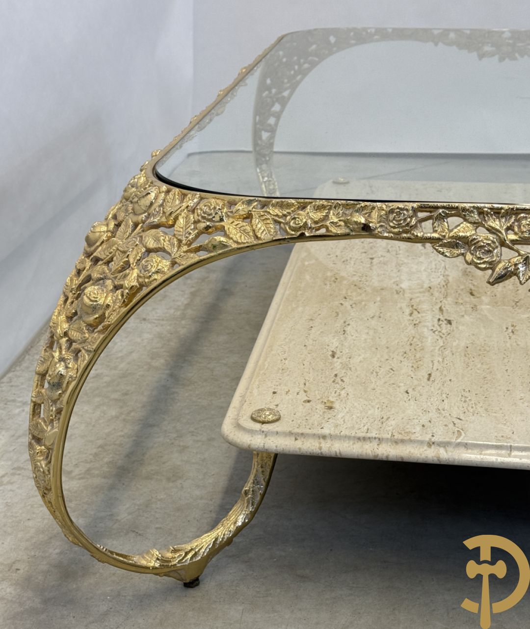 Salontafel met glazen blad op gebogen voluutvormige koperen poten gemaakt van bladranken - onderaan met travertin blad