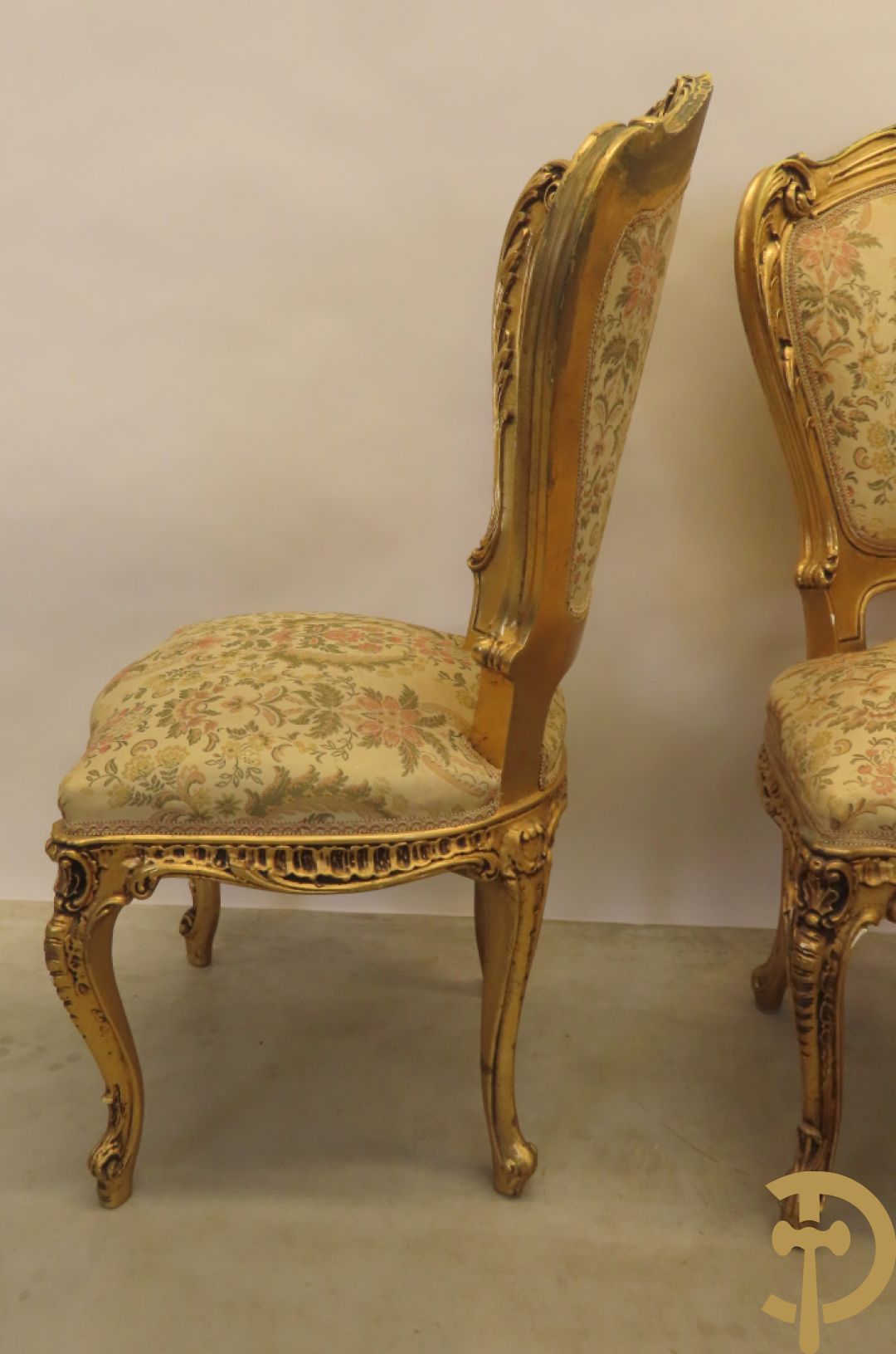 Uitzonderlijke vergulde Louis XV eetkamer bestaande uit vijfdeursdressoir met voluutvormige accanthusranken en rocailles, beschilderd met bloemenmotieven en centraal tafererel met hoornen des overvloeds + bijhorende spiegel vergulde tafel op voluutvormige poten met zes bijhorende stoelen + vitrine met accanthusranken en centrale deur, op voluutvormige poten