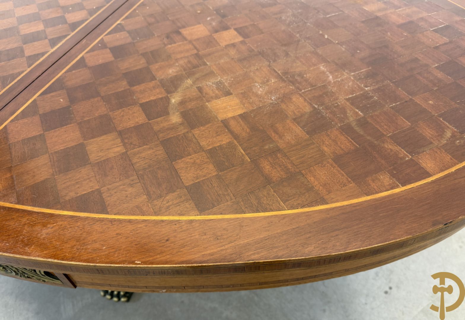 Ovale geparketteerde notelaren tafel bezet met bronzen ornamenten, Art deco Decoene