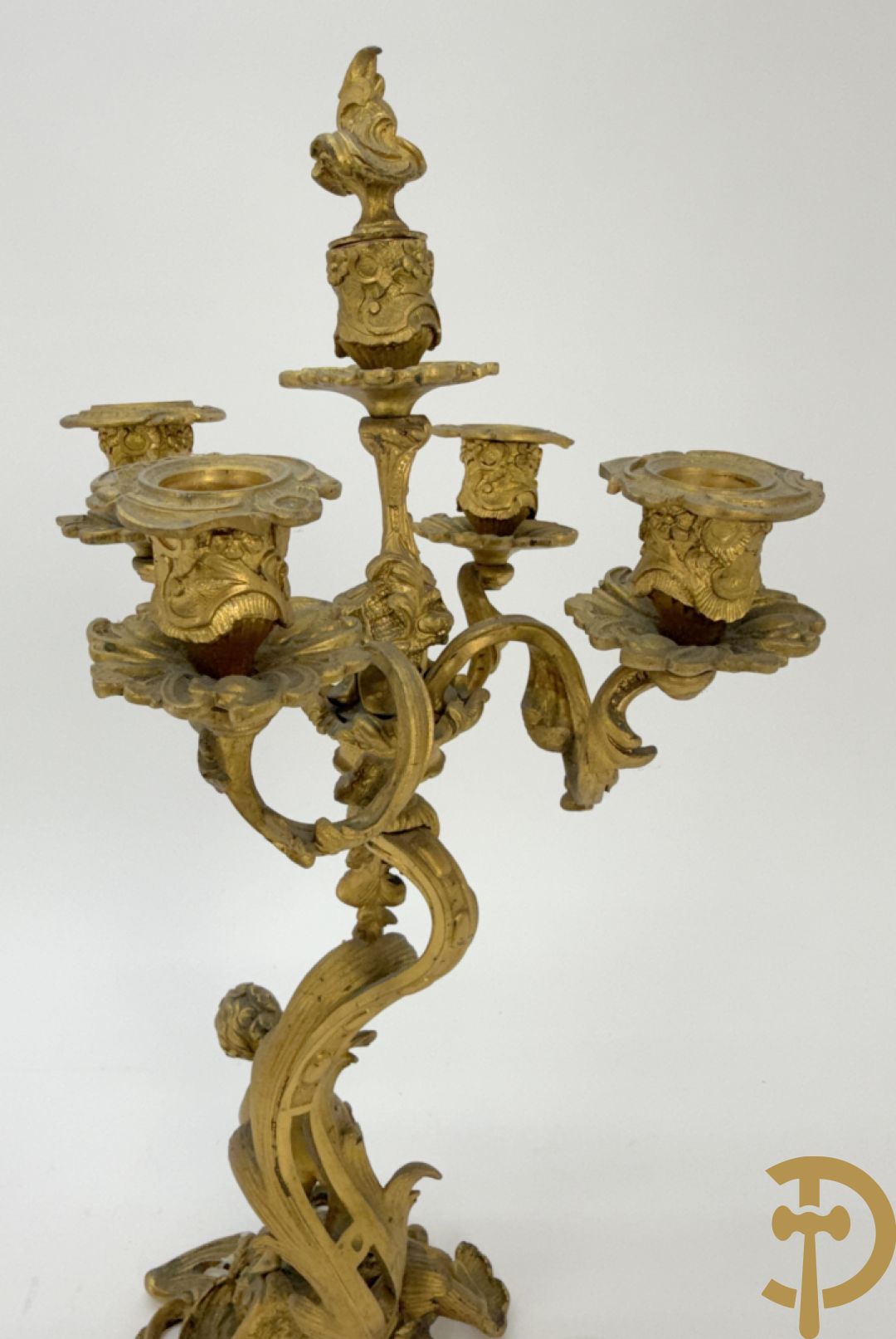 Driedelige vuurvergulde bronzen garnituur, Louis XV stijl, bestaande uit middenstuk met klok omgeven door musicerende cupido