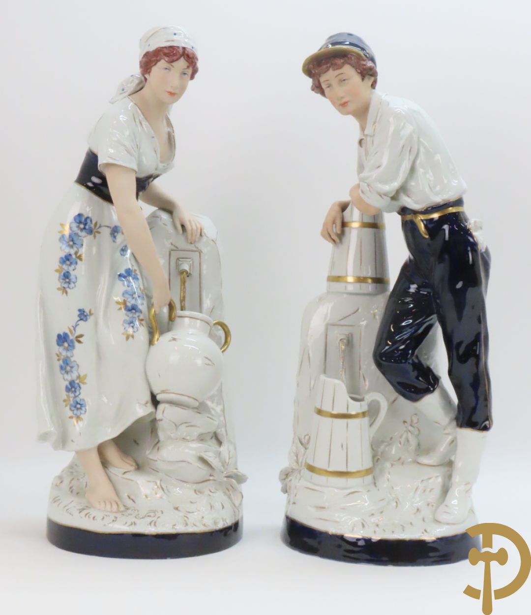 Paar Royal Dux personages van dame en heer bij de waterkraan, onderaan gemerkt en genummerd 10965 en 10563