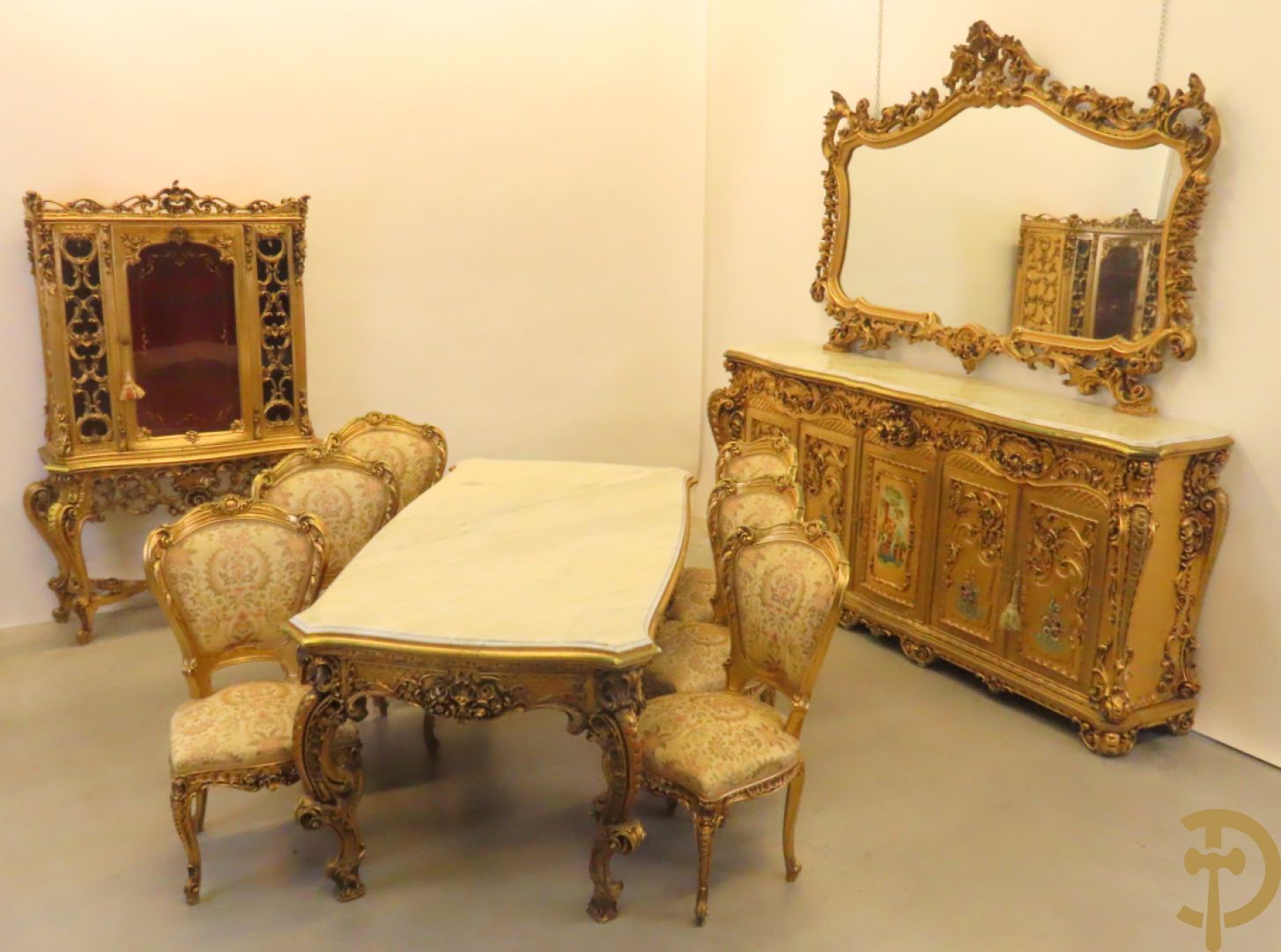 Uitzonderlijke vergulde Louis XV eetkamer bestaande uit vijfdeursdressoir met voluutvormige accanthusranken en rocailles, beschilderd met bloemenmotieven en centraal tafererel met hoornen des overvloeds + bijhorende spiegel vergulde tafel op voluutvormige poten met zes bijhorende stoelen + vitrine met accanthusranken en centrale deur, op voluutvormige poten