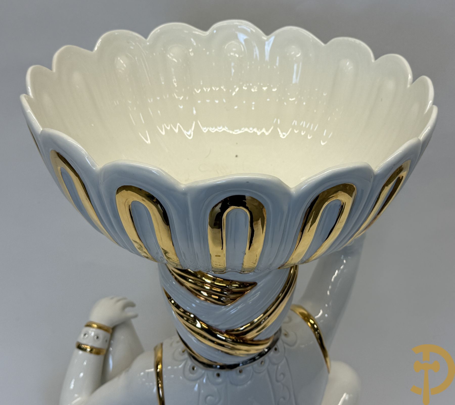 Porseleinen sierbeeld van olifant als staander met daarboven jongeman met bloemencachepot