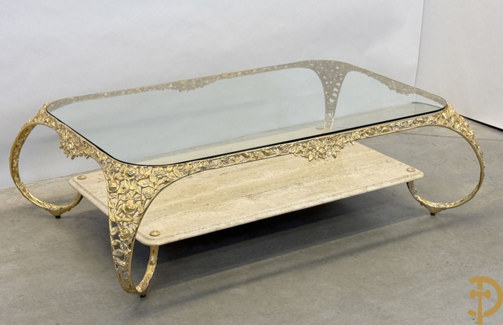 Salontafel met glazen blad op gebogen voluutvormige koperen poten gemaakt van bladranken - onderaan met travertin blad