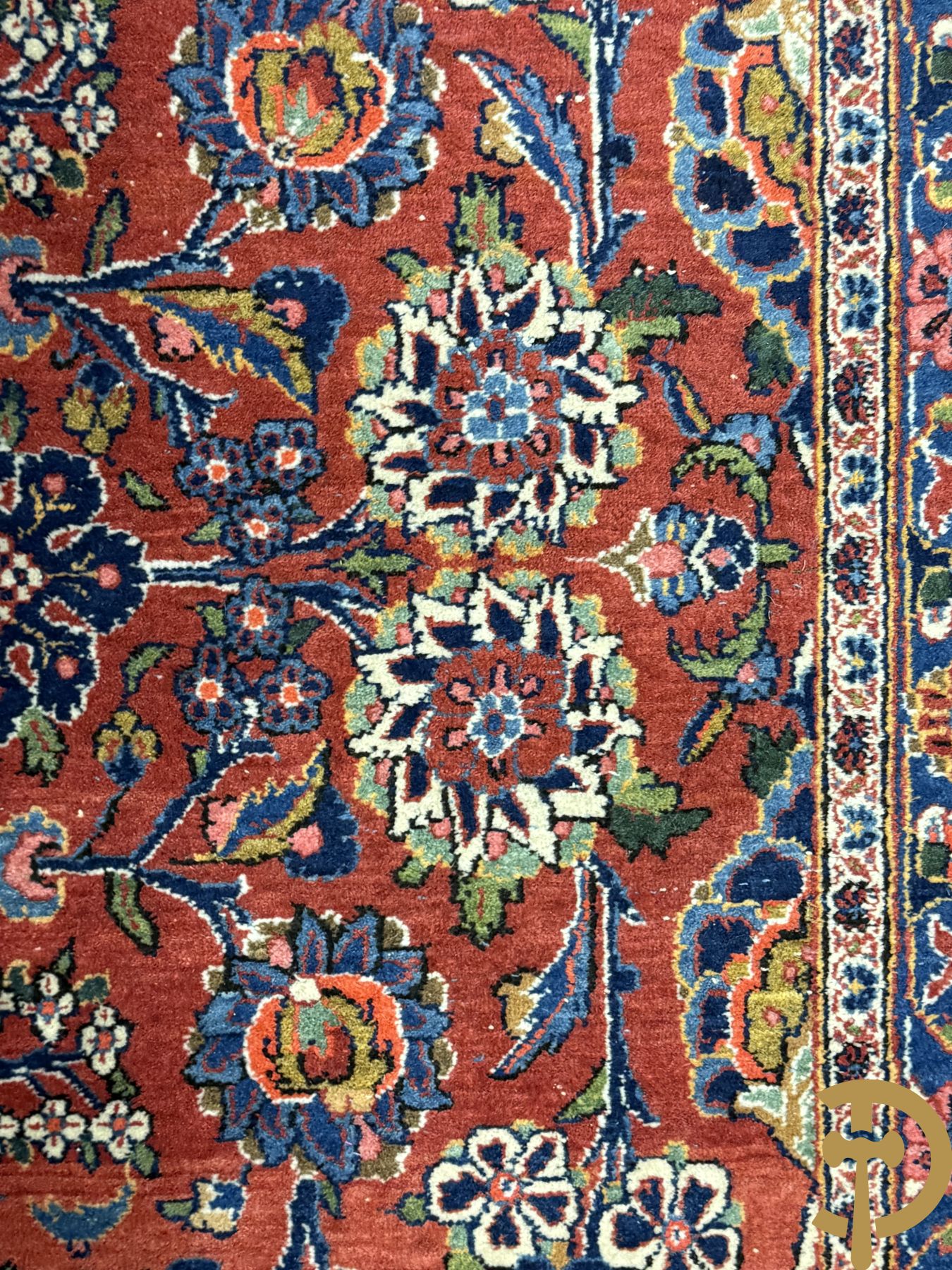 Oosters handgeknoopt tapijt met bloemenmotieven op rode fond