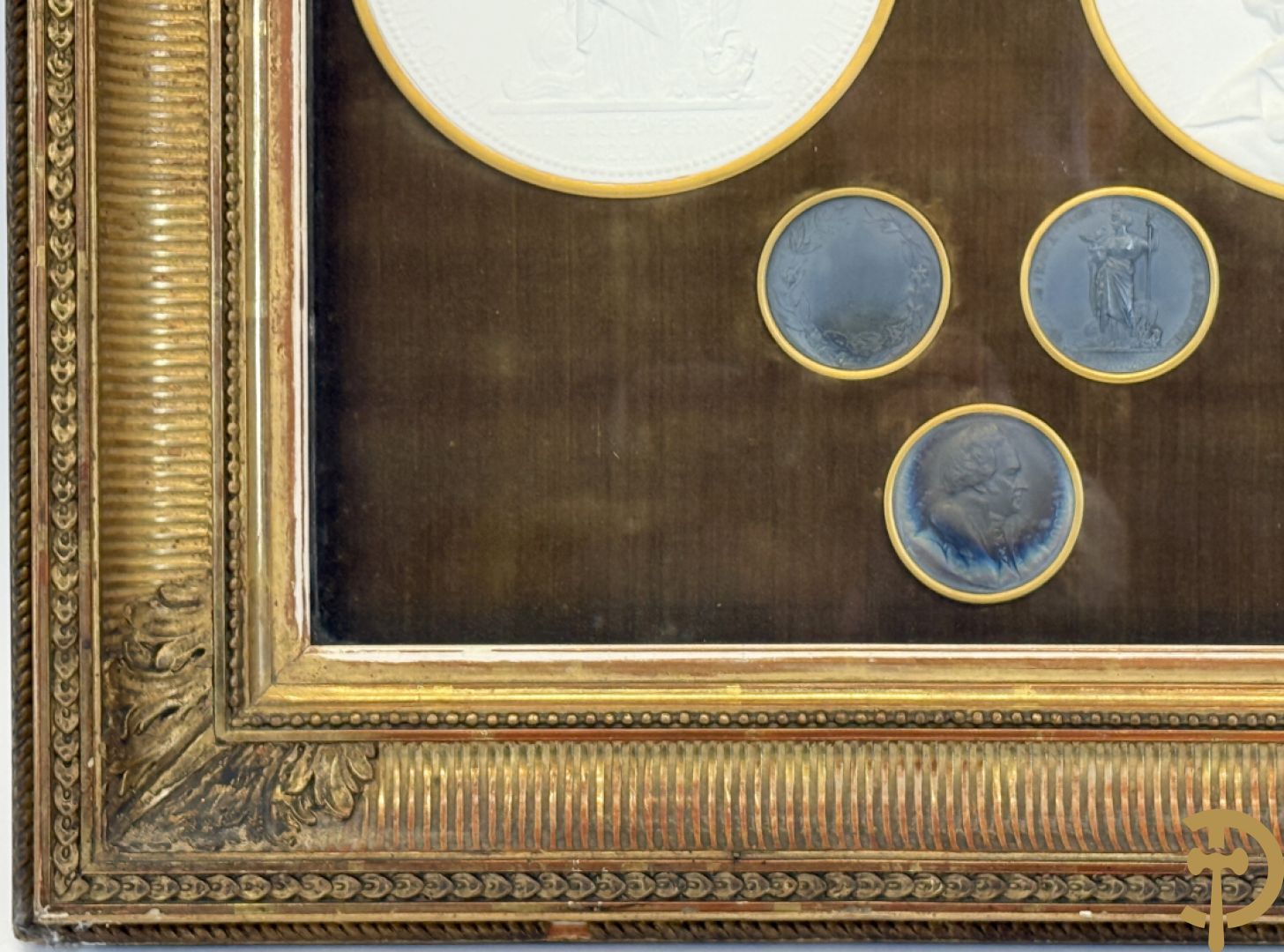 Kader met twee porseleinen plakkettes en 3 munten van Oudiné Eugène André