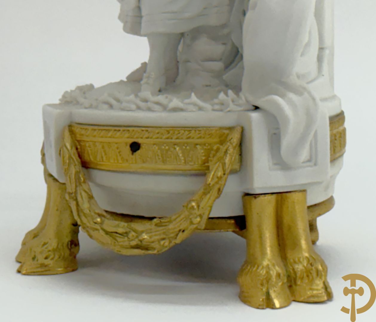 Driedelige porseleinen garnituur met bronsbeslag bestaande uit pendule met dame en amfoor geflankeerd door paar kandelaars bezet met personages