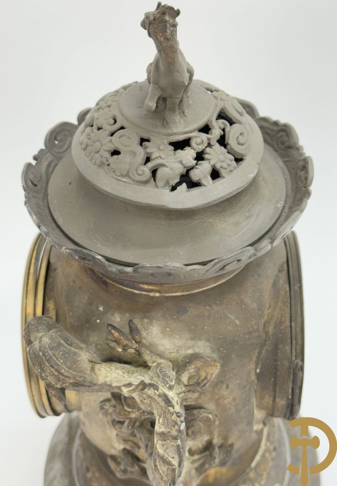 Aziatische pendule in zamak, zijdelings bezet met drakendecor en bovenaan met mythologisch figuur