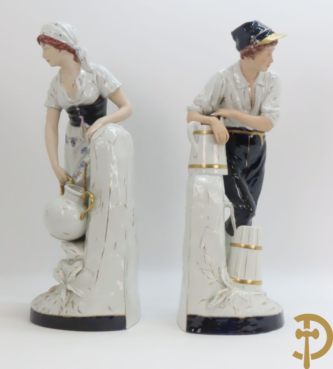 Paar Royal Dux personages van dame en heer bij de waterkraan, onderaan gemerkt en genummerd 10965 en 10563