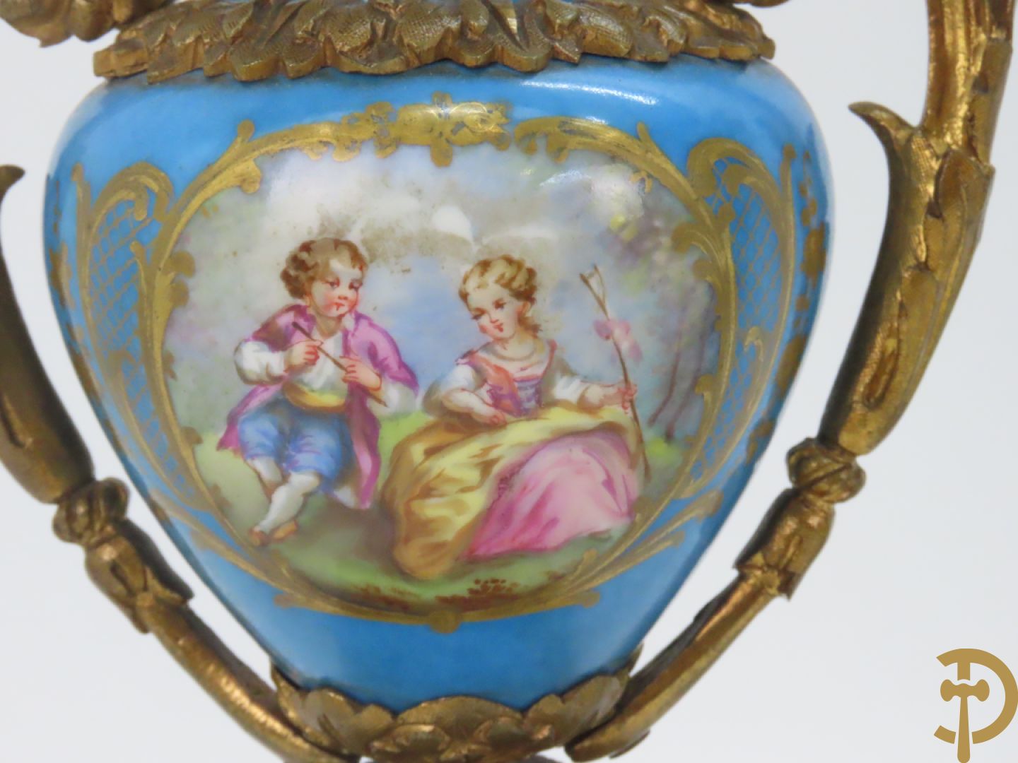 Driedelige bronzen garnituur bezet met Sèvres porselein bestaande uit pendule geflankeerd door paar cupido