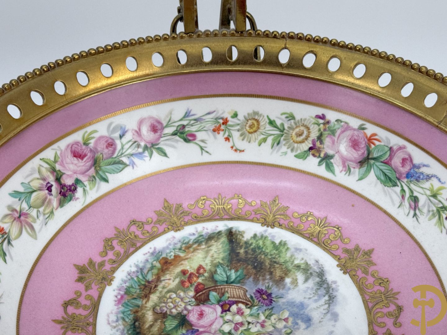 Porseleinen coupe met centraal tafereel en omringd met bloemendecor, gevat in bronzen houder