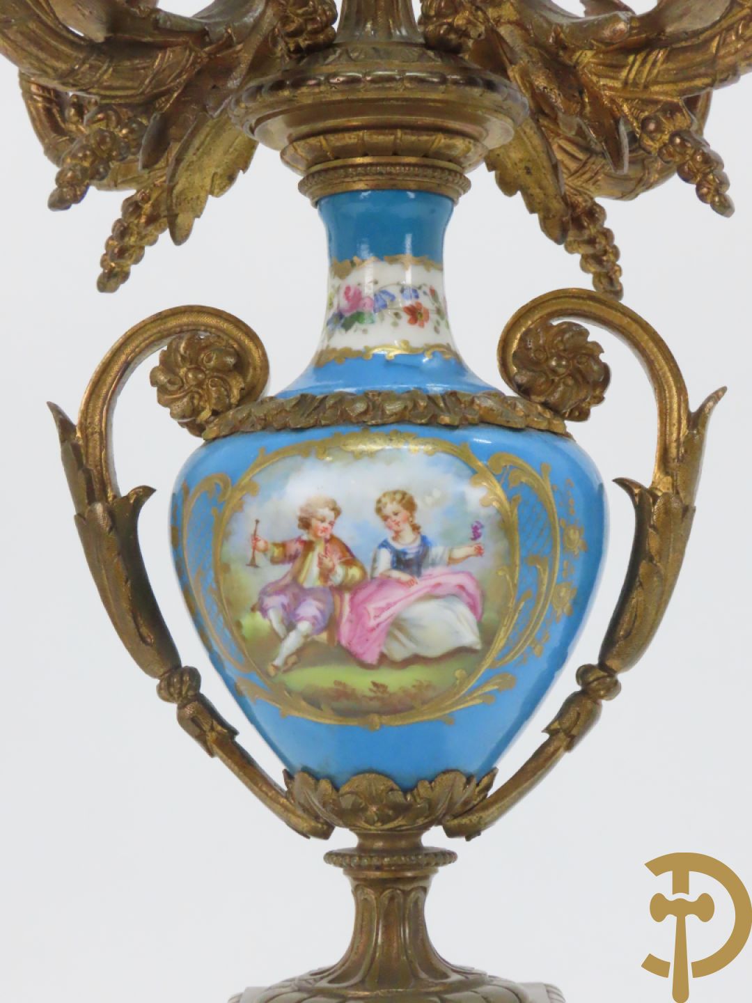 Driedelige bronzen garnituur bezet met Sèvres porselein bestaande uit pendule geflankeerd door paar cupido