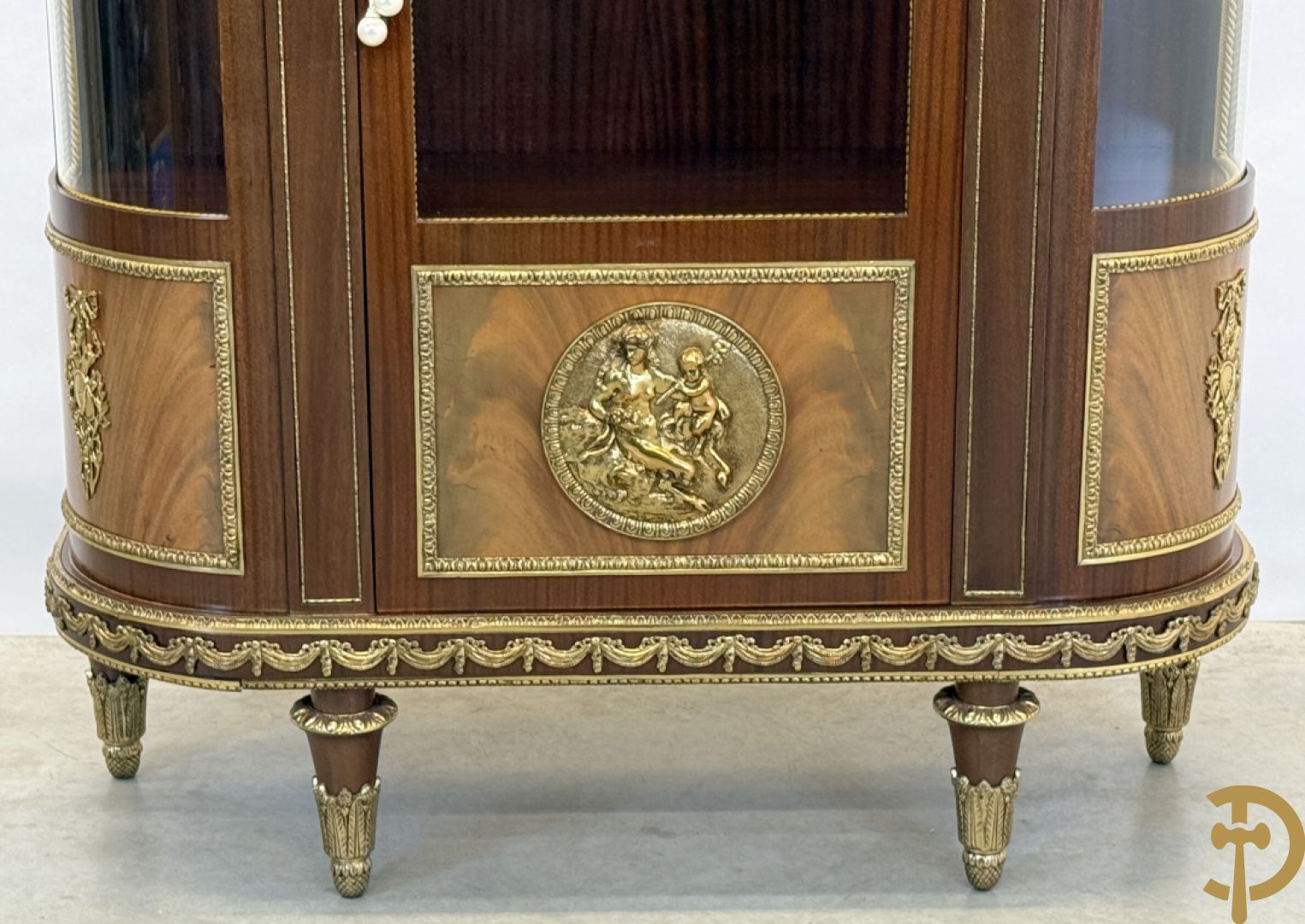 Notelaren vitrine met afgeronde zijkanten, bezet met bronzen plakkettes van dame en cupido