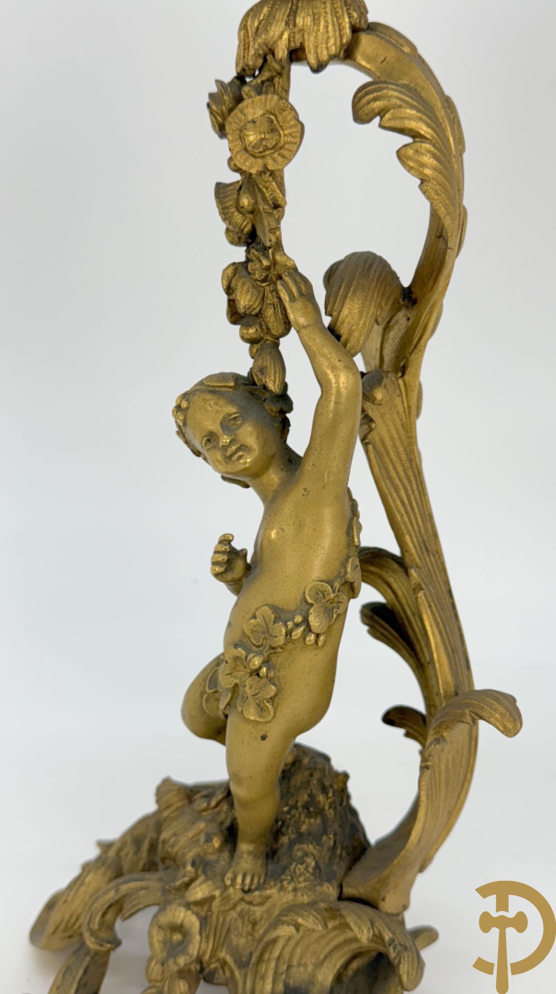 Driedelige vuurvergulde bronzen garnituur, Louis XV stijl, bestaande uit middenstuk met klok omgeven door musicerende cupido