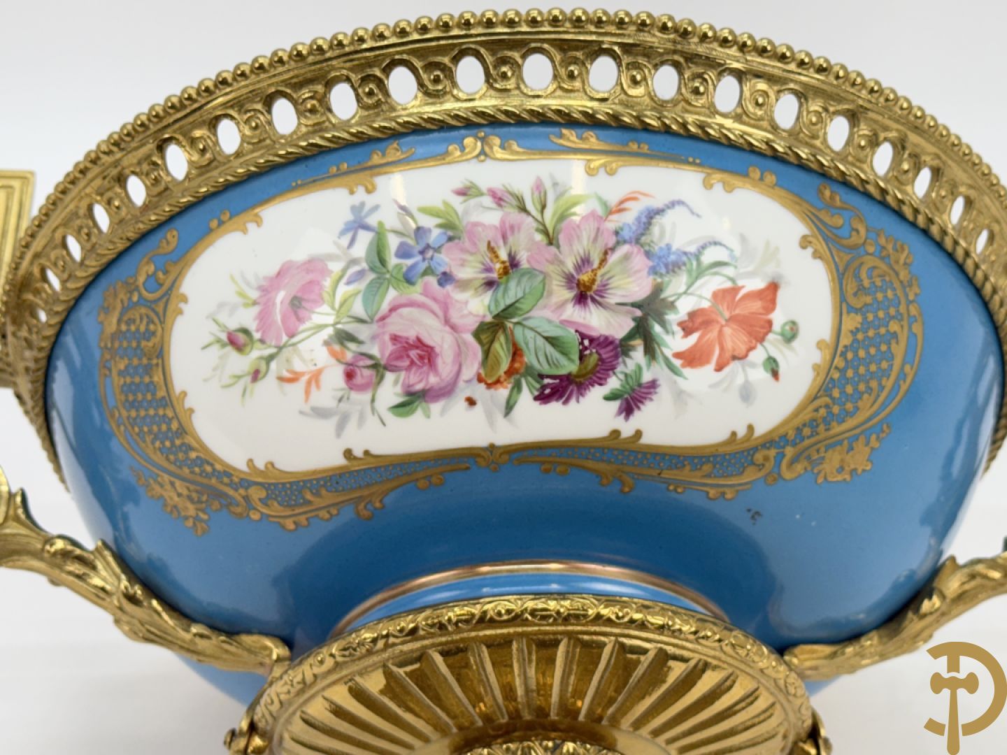Porseleinen coupe met centraal tafereel en omringd met bloemendecor, gevat in bronzen houder