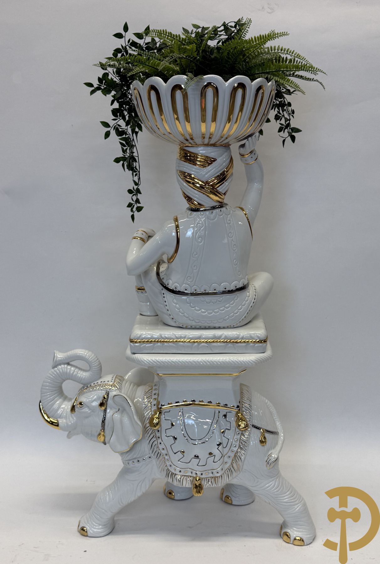 Porseleinen sierbeeld van olifant als staander met daarboven jongeman met bloemencachepot