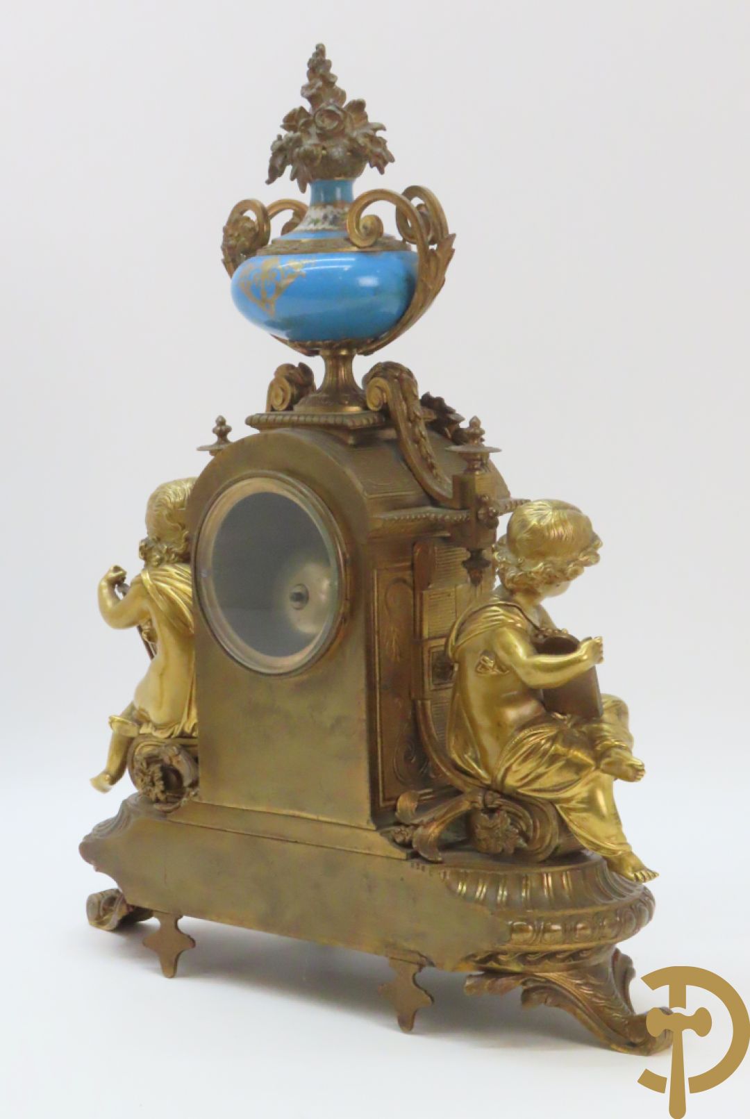 Driedelige bronzen garnituur bezet met Sèvres porselein bestaande uit pendule geflankeerd door paar cupido