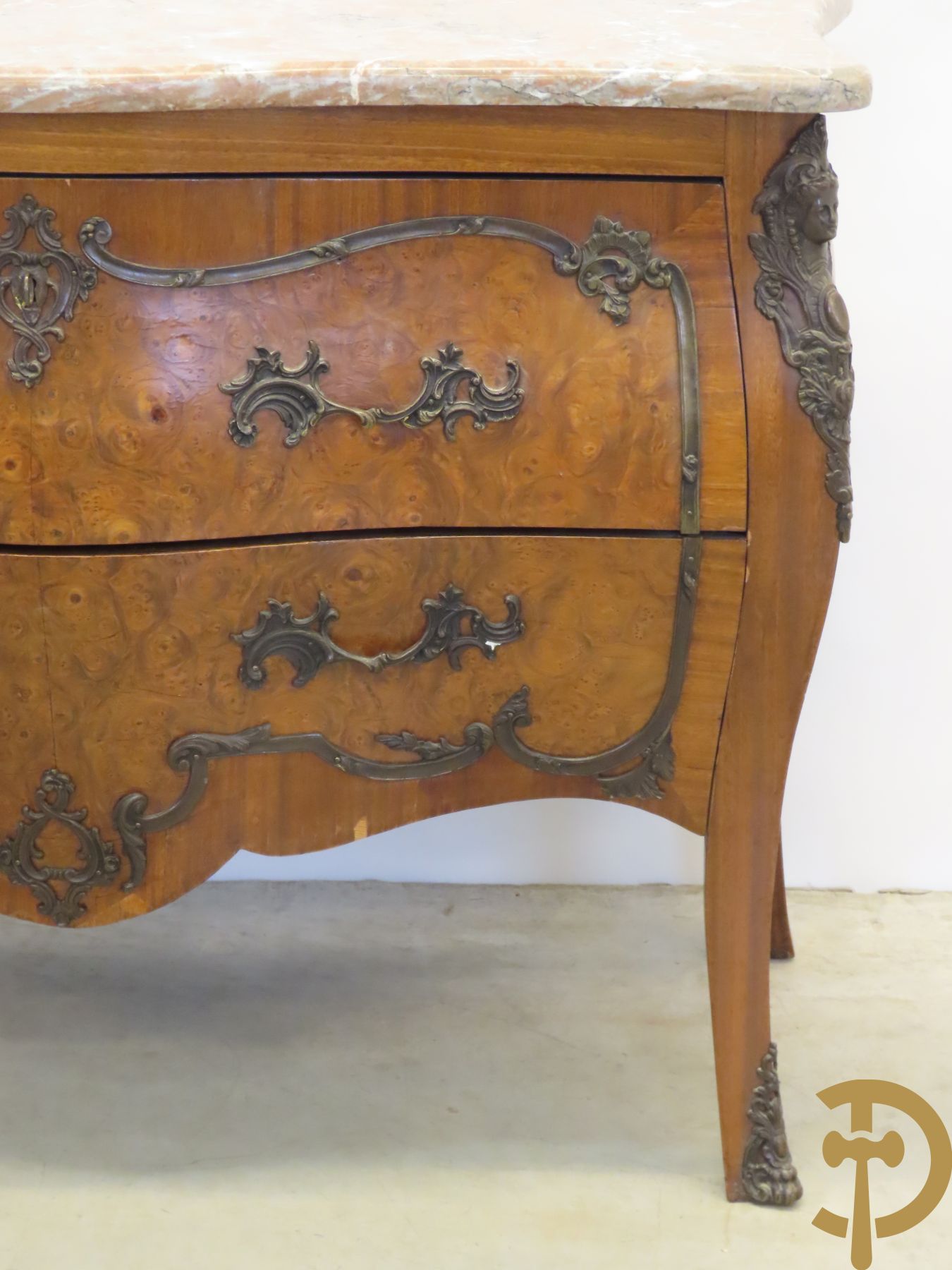 Wortelnotehouten gegalbeerde tweeladencommode met bronzen accanthusranken op lades, bronzen trekkers en dameshoofden opzij