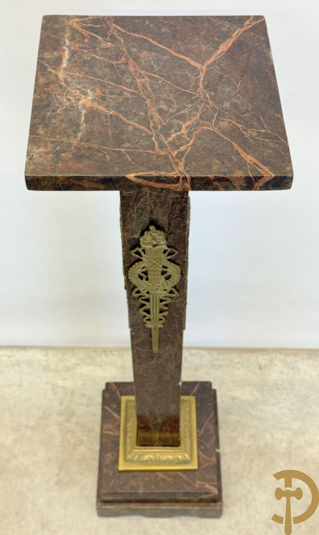 Bruin geaderde marmeren zuil met bronzen ornamenten
