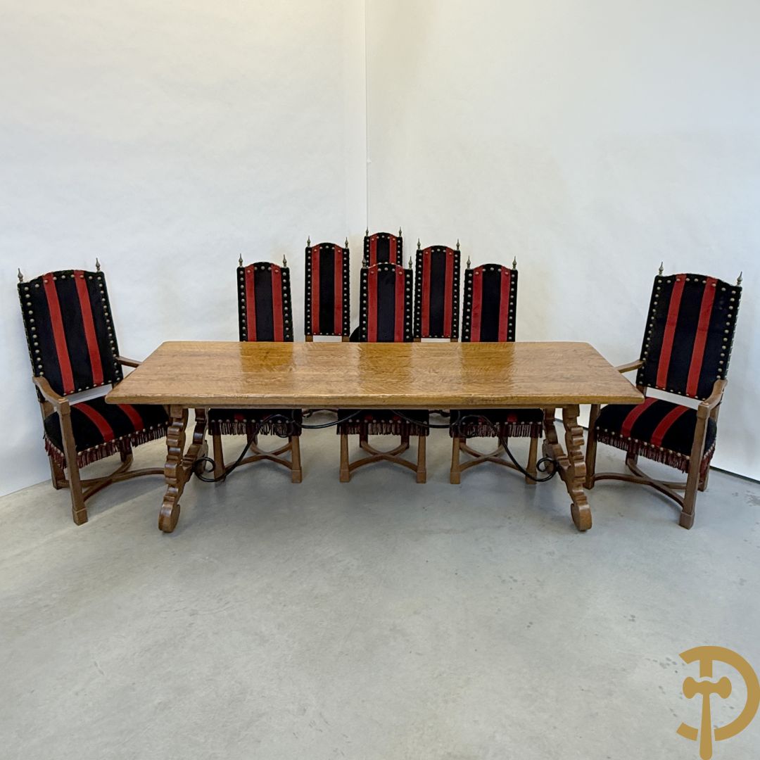 Massief eiken tafel met wangen en smeedijzer verbonden + 6 hoogleunige stoelen + 2 armzetels
