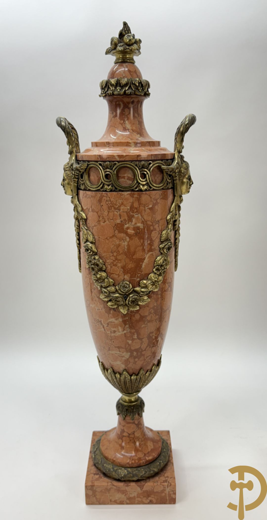 Paar oranje/rode marmeren cassolettes, zijdelings bezet met dameshoofden dragende een guirlande van bloemen - bovenaan met bloementroffee