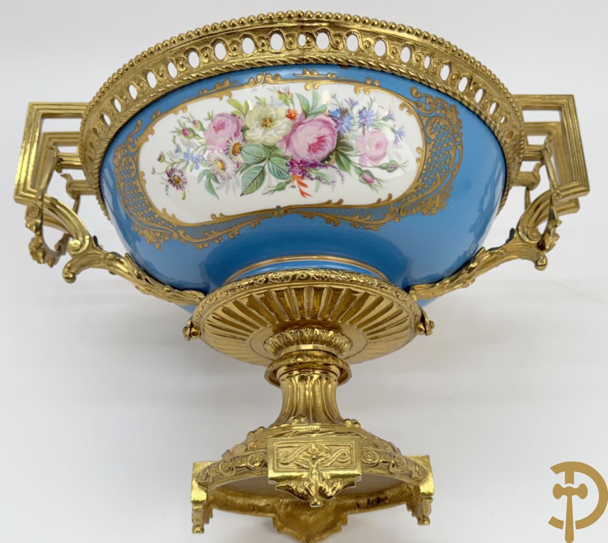 Porseleinen coupe met centraal tafereel en omringd met bloemendecor, gevat in bronzen houder