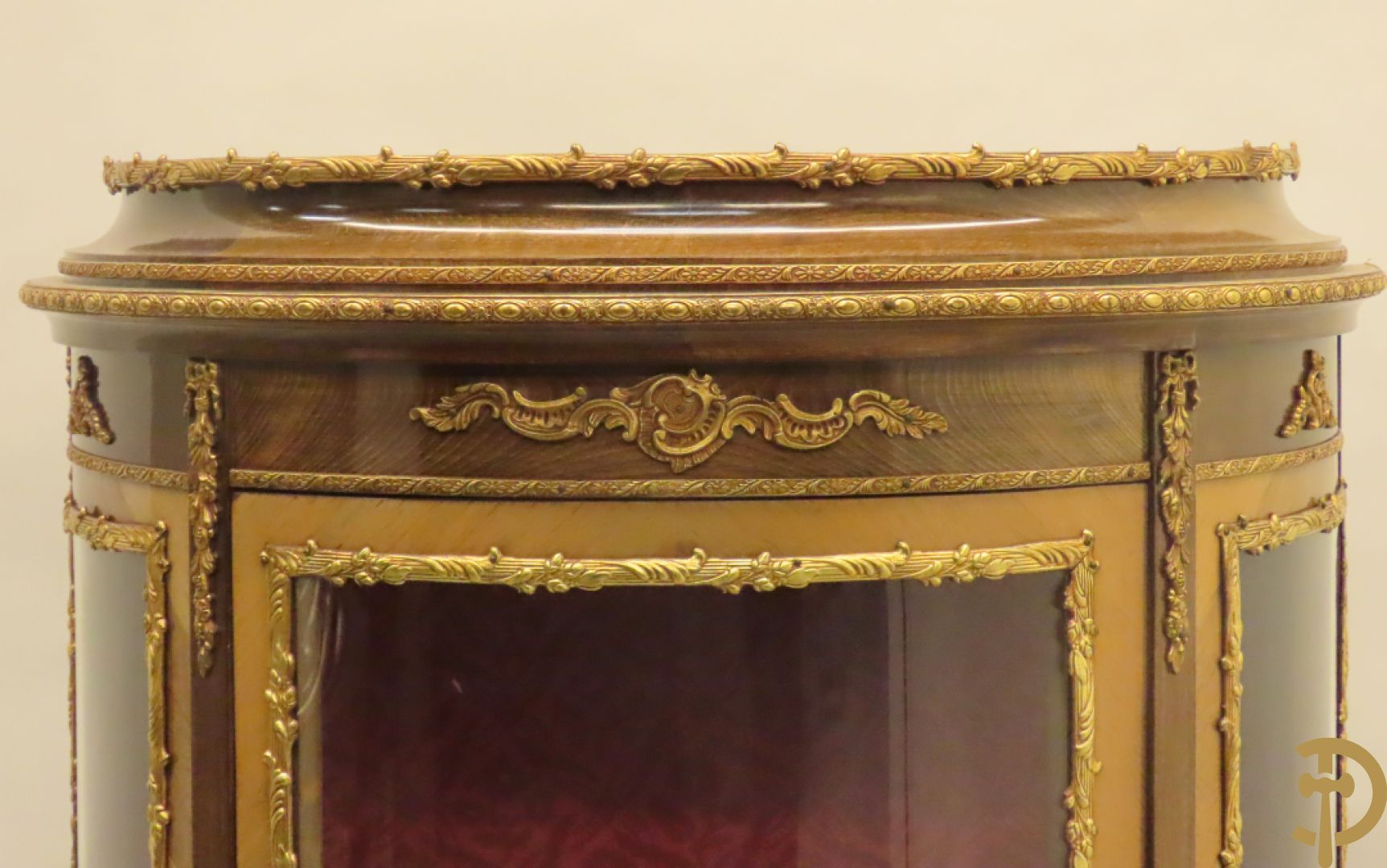 Gebogen notelaren vitrine met bronsbeslag en geanimeerd romantisch tafereel onderaan