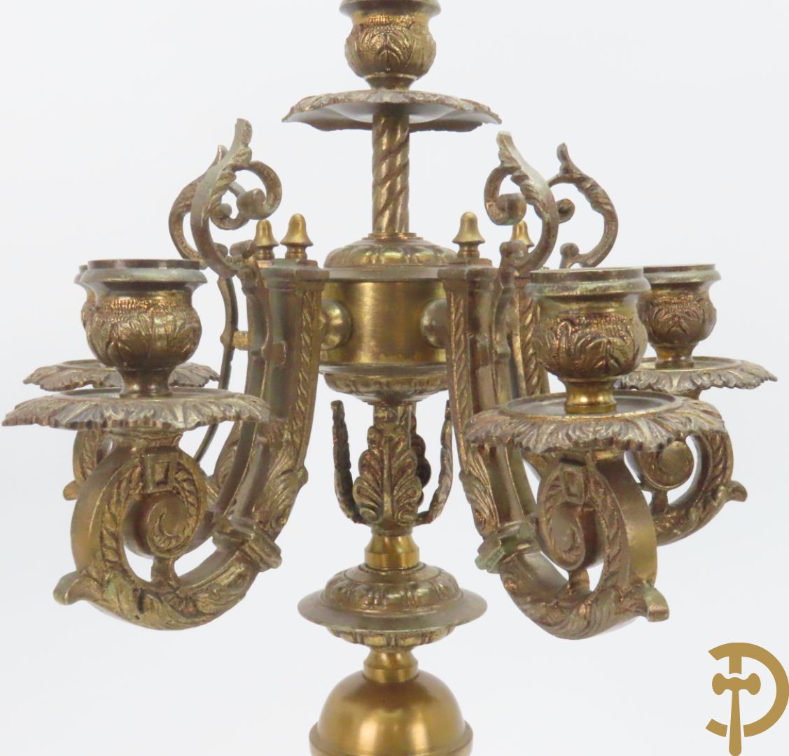 Driedelige bronzen garnituur bestaande uit pendule met 2 dames bovenaan, geflankeerd door paar zesarmige kandelaars