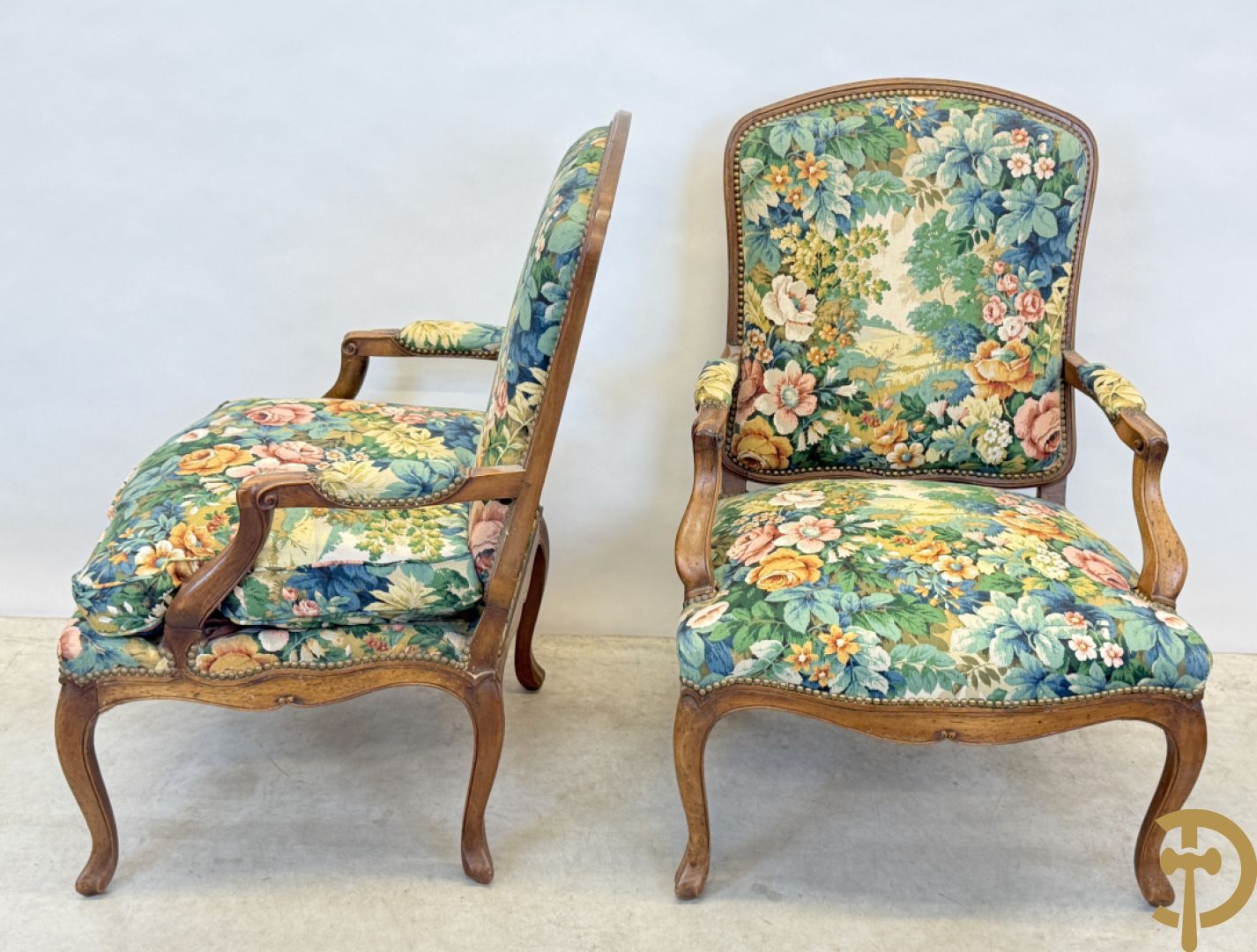 Vier notelaren armzetels bekleed met bloemenstof, met gezwaaide armleuningen op voluutvormige poten + bijhorend voetbankje