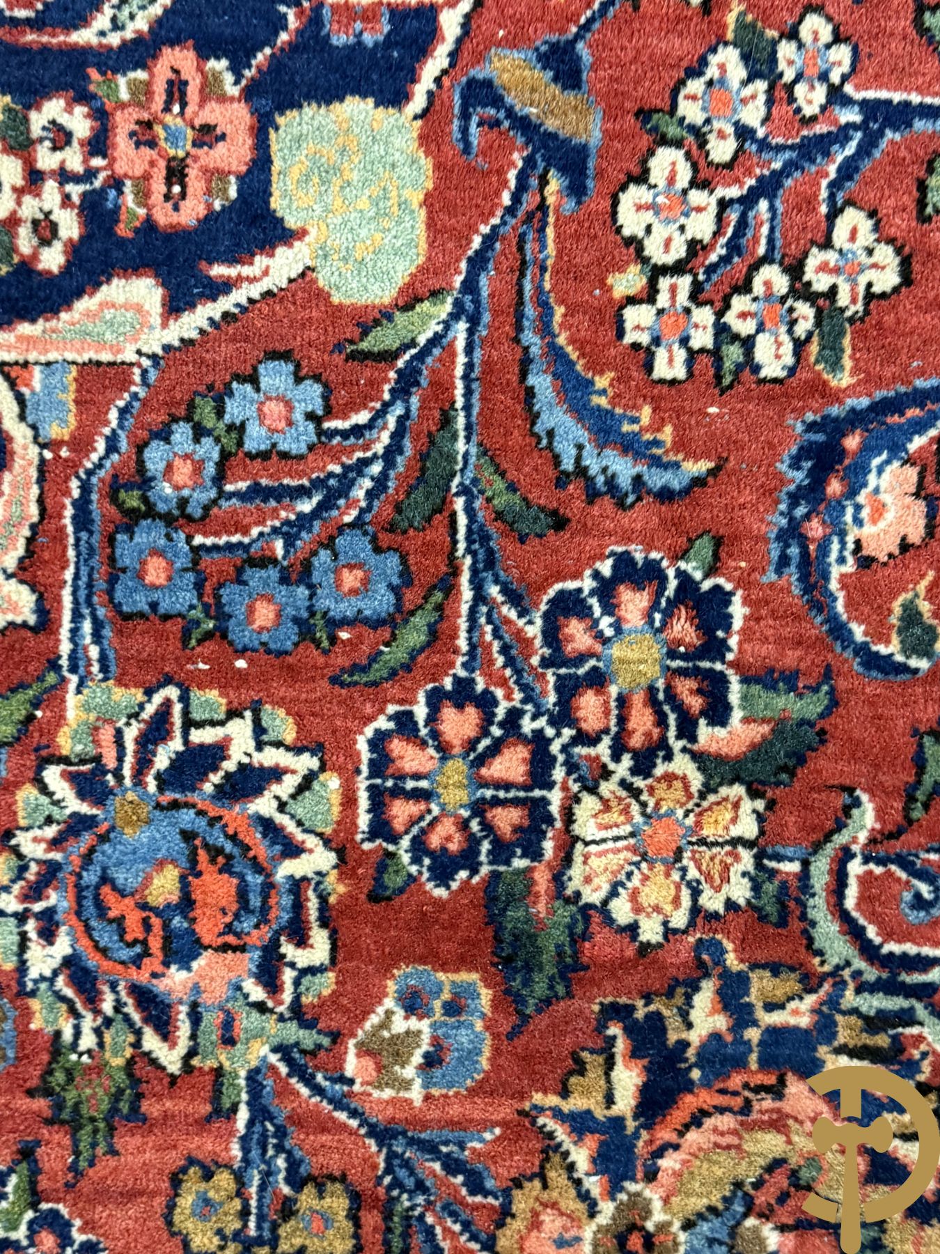 Oosters handgeknoopt tapijt met bloemenmotieven op rode fond