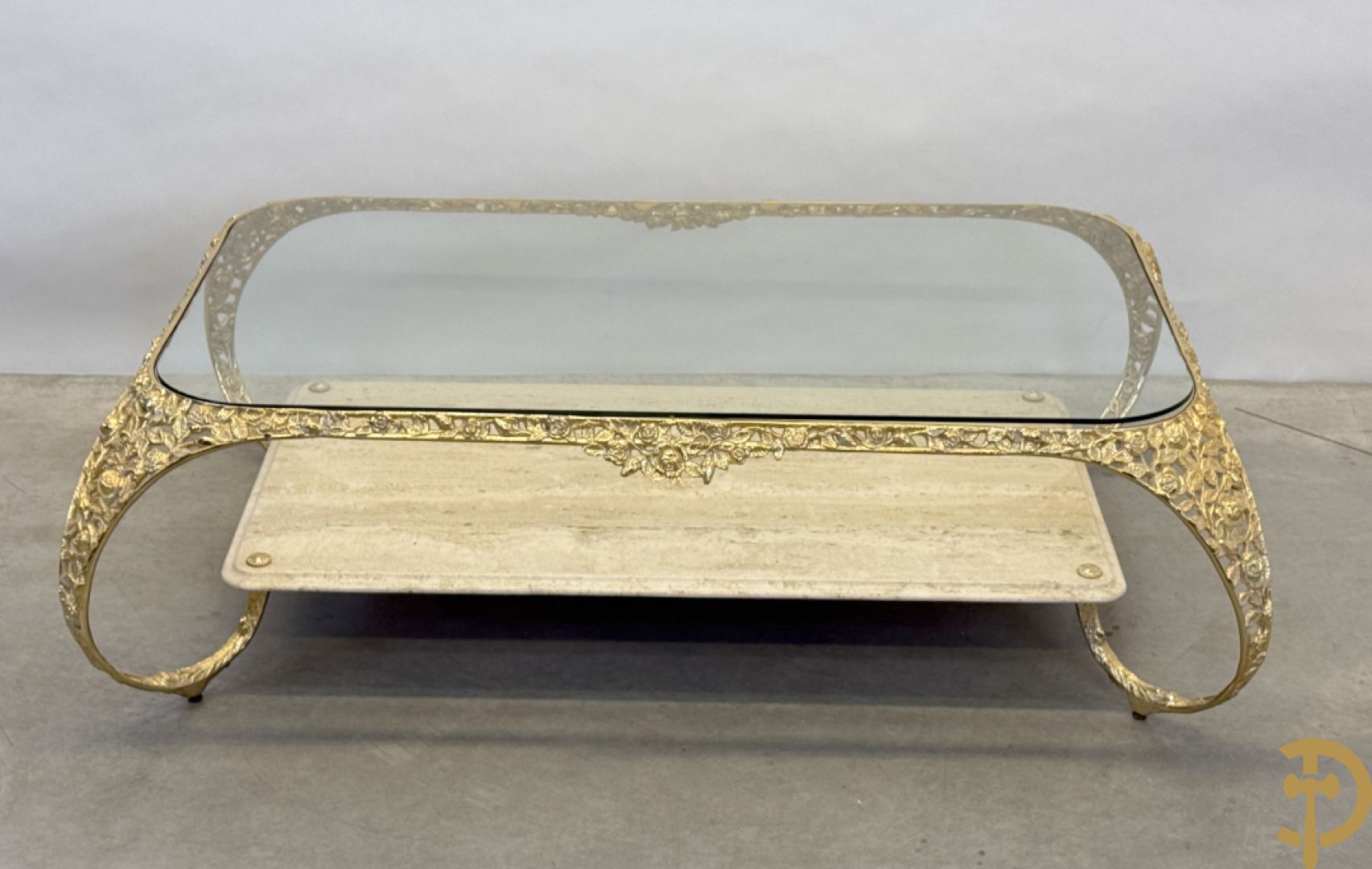 Salontafel met glazen blad op gebogen voluutvormige koperen poten gemaakt van bladranken - onderaan met travertin blad