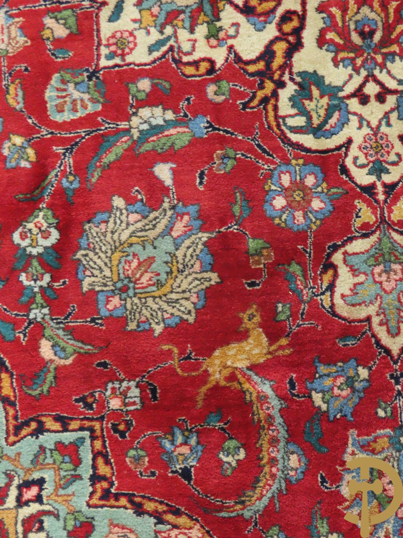 Oosters handgeknoopt tapijt met bloemen, dierenmotieven en centraal decor op rode fond