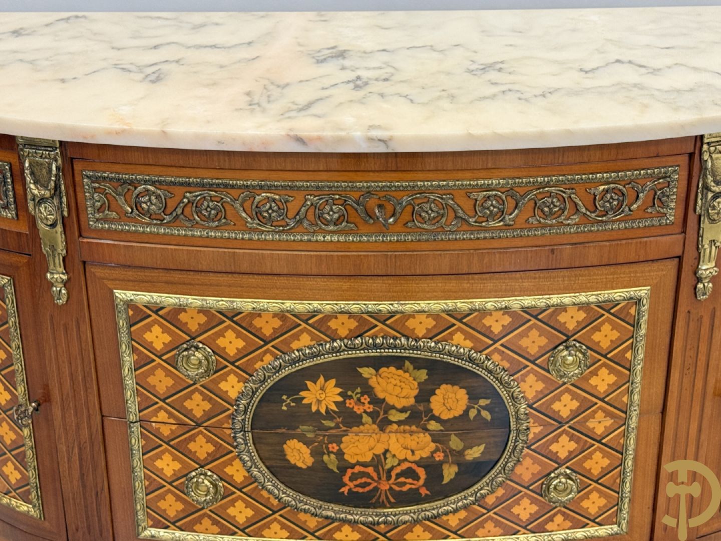 Halve maanvormige drieladencommode met 2 zijdelingse deuren, gemarketteerde bloemenmotieven en bronzen ornamenten, bovenaan bezet met marmeren blad