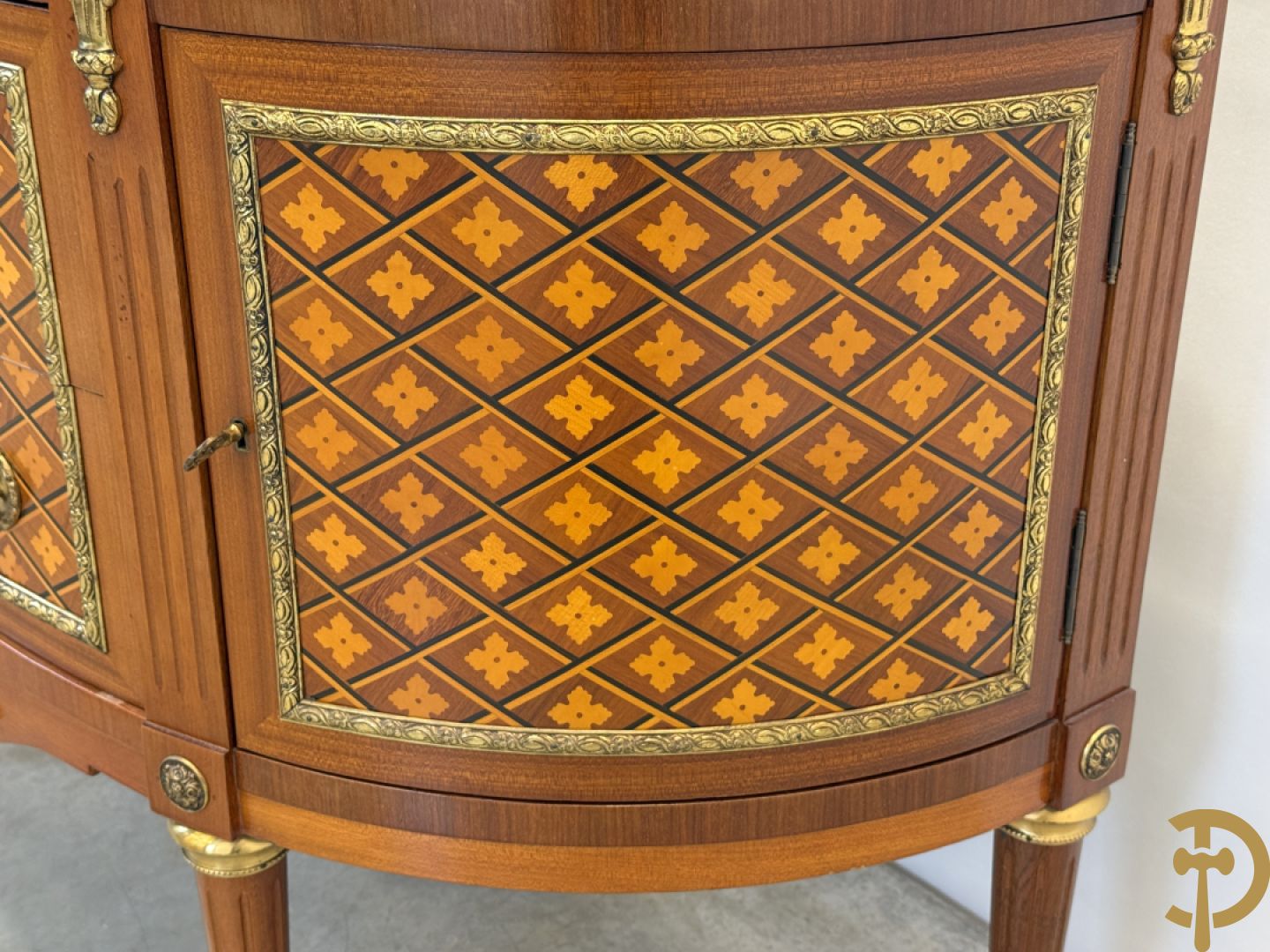 Halve maanvormige drieladencommode met 2 zijdelingse deuren, gemarketteerde bloemenmotieven en bronzen ornamenten, bovenaan bezet met marmeren blad
