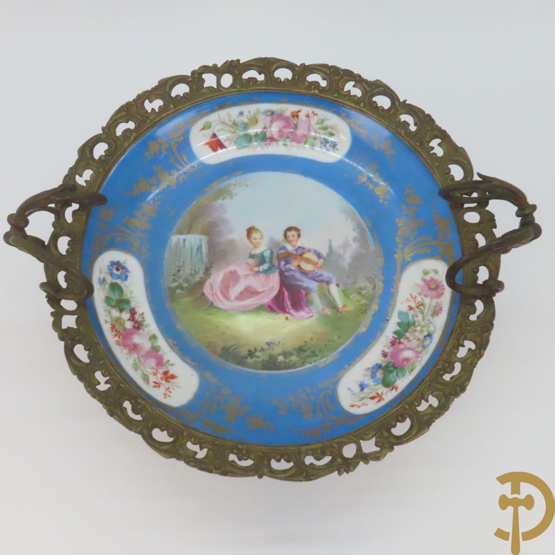 Porseleinen Sèvres schotel met handbeschilderd romantisch tafereel van lieflijk koppel gevat in bronzen houder - bezet met dameshoofden en accanthusranken, onderaan gemerkt Sèvres