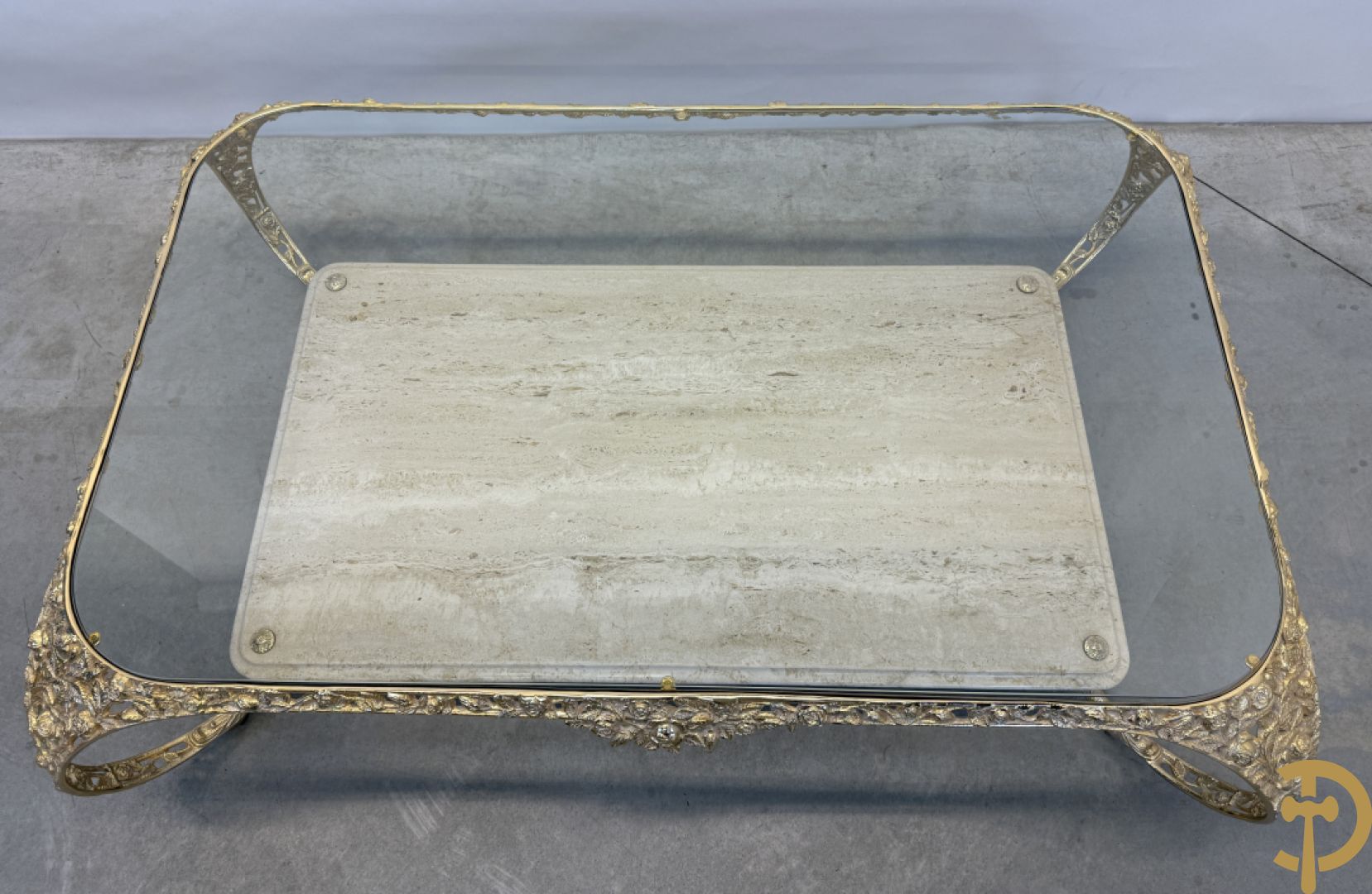 Salontafel met glazen blad op gebogen voluutvormige koperen poten gemaakt van bladranken - onderaan met travertin blad