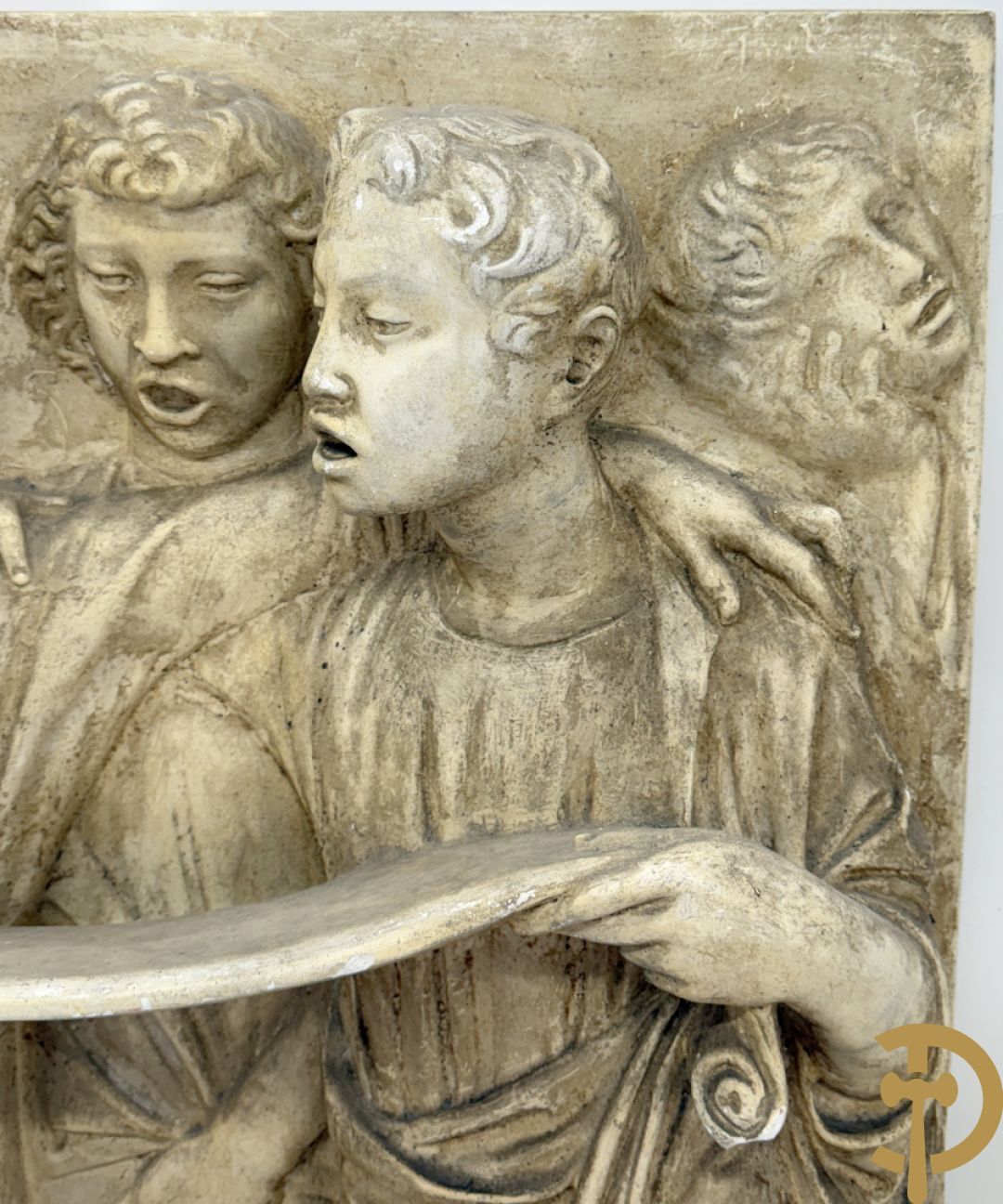 Gipsen basrelief met een zingend jongerenkoor