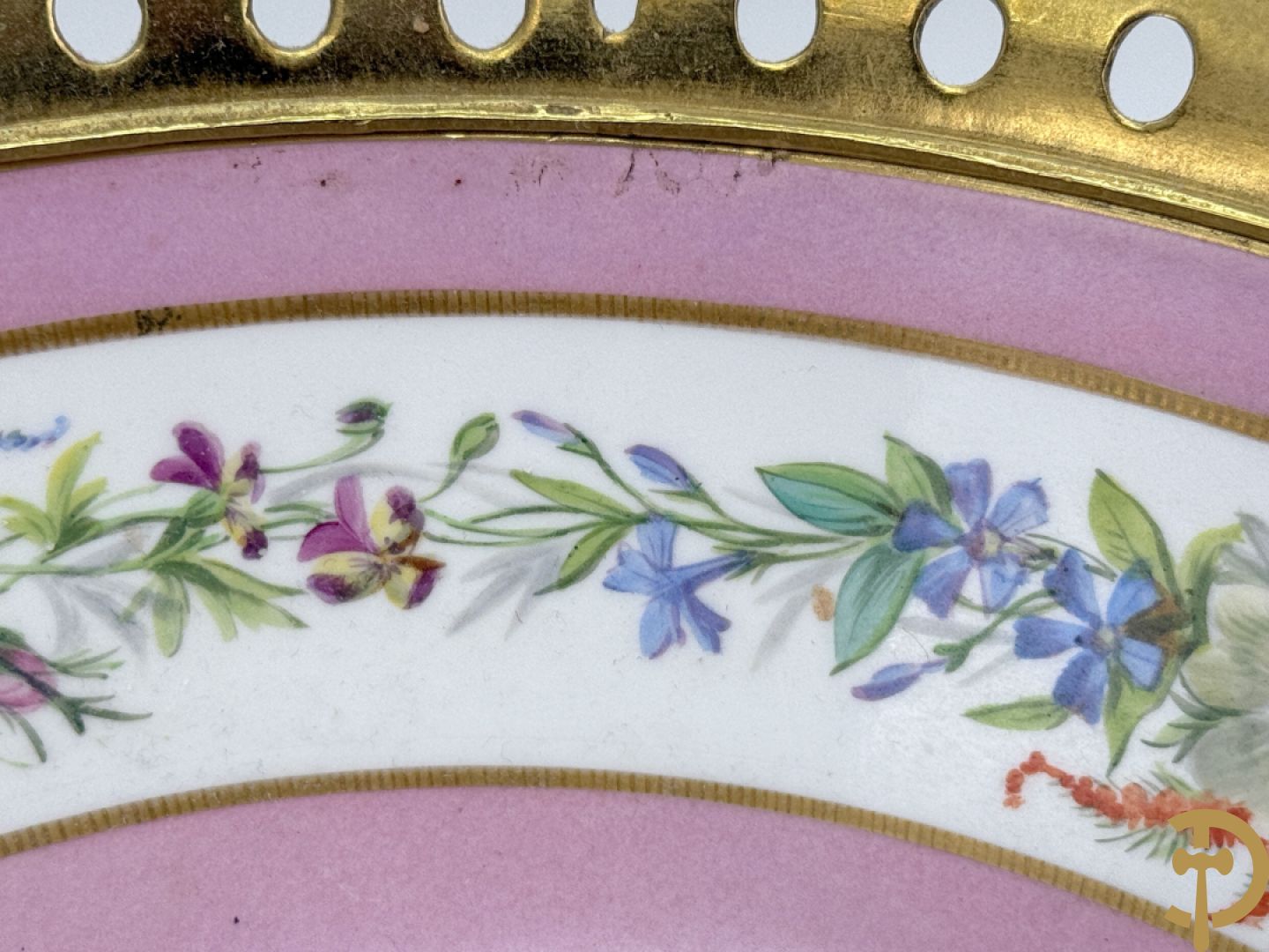 Porseleinen coupe met centraal tafereel en omringd met bloemendecor, gevat in bronzen houder