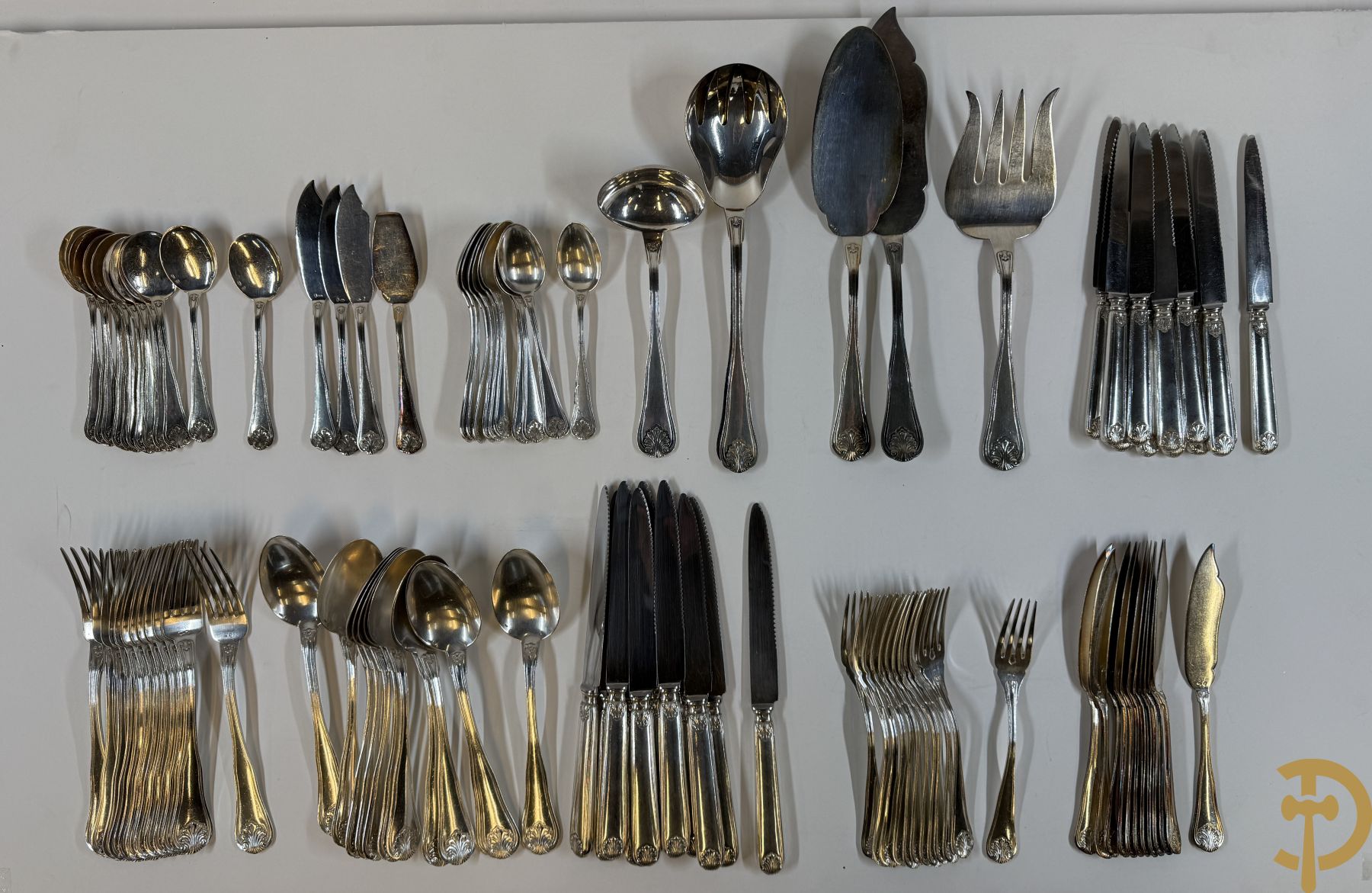 Massief zilveren bestek Wolfers bestaande uit 12 vorken (979 gram), 12 lepels (1028 gram), 11 messen, 12 visvorken (553 gram), 12 vismessen (690 gram), 12 dessertmessen, 10 koffielepels (296 gram), 12 ijslepels (369 gram), 3 botermesjes en scheplepeltje (165 gram), 5  grote stukken (samen 557 gram) waarvan slacouvert, 2 taartscheppen en wildvork + sauslepel met zelfde decor maar Metal Blanc