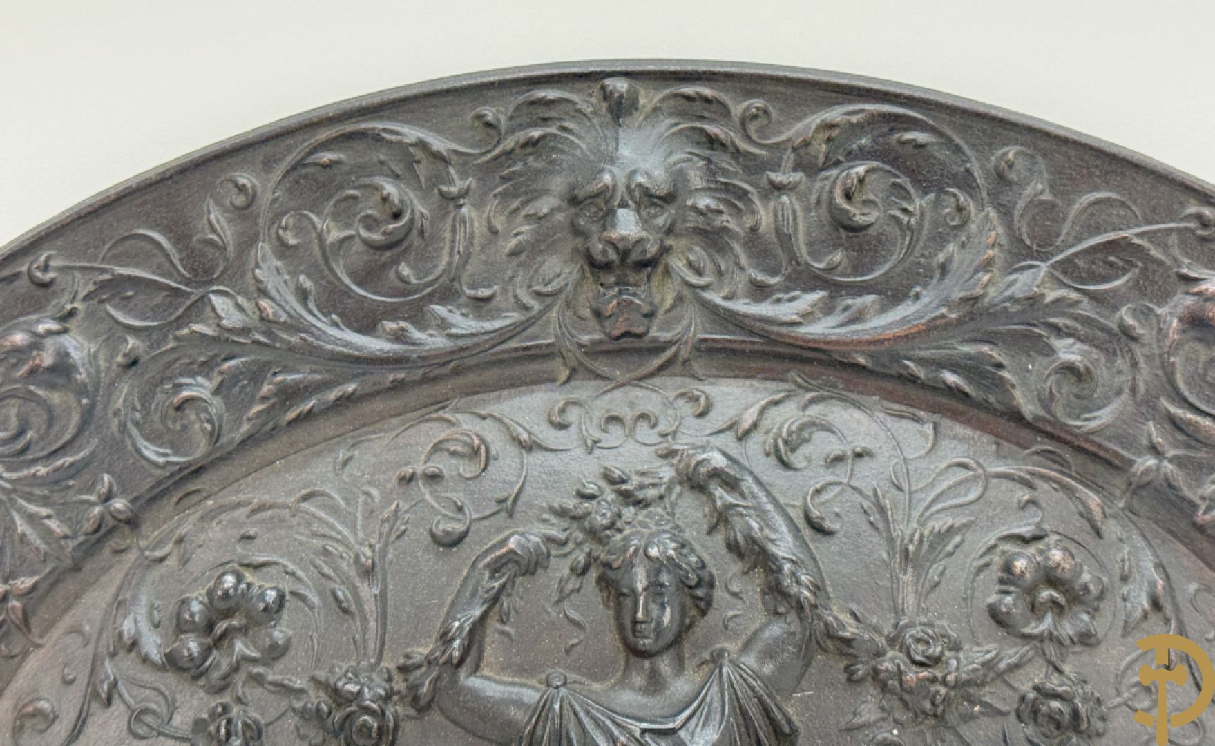 Metalen ovale schotel met dame omgeven door bloemen en accanthusranken, achteraan getekend American Radiator Cie