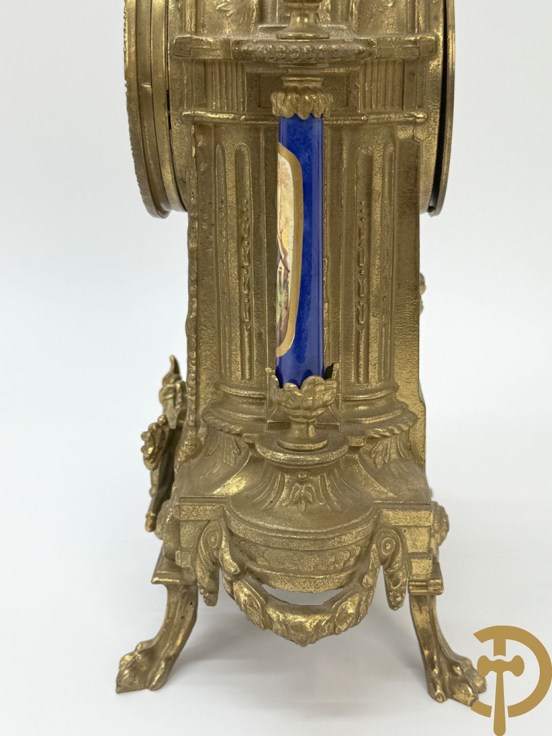 Driedelige koperen garnituur bestaande uit pendule met beschilderd romantisch tafereel en amfoor, zijdelings bezet met paar cassolettes met geanimeerde scènes, onleesbaar getekend rechts onder klok