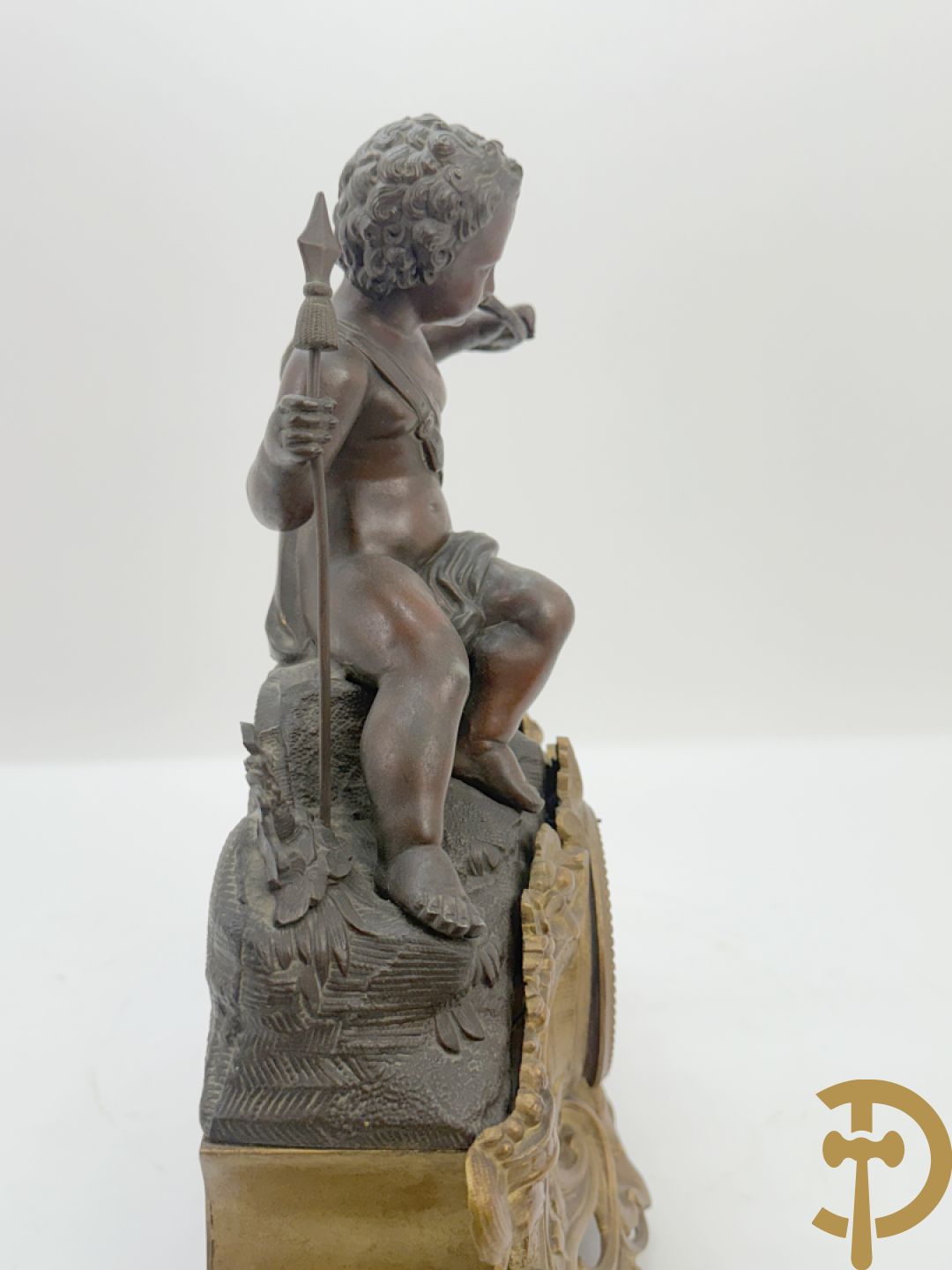 Zamak pendule met accanthusranken en bekroond met cupido met jachthoorn