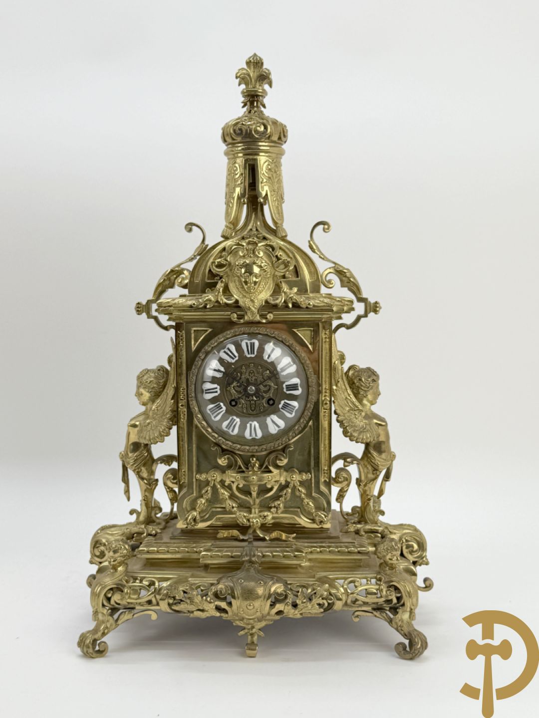 Driedelige bronzen vergulde garntiuur bestaande uit klok met medusahoofden en sfinxen, geflankeerd door paar zevenarmige kandelaars met accanthusranken en sfinxen