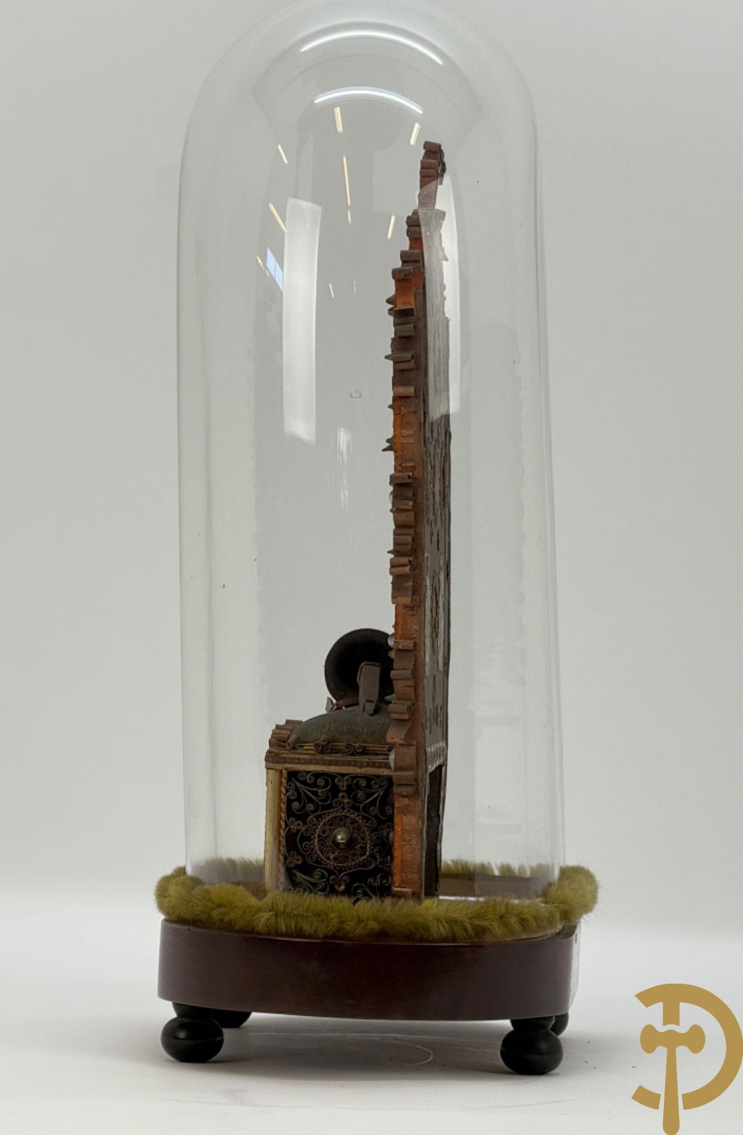 Relikwiehouder in de vorm van een altaar met Christusnagel en omgeven door papperollen - onder stolp