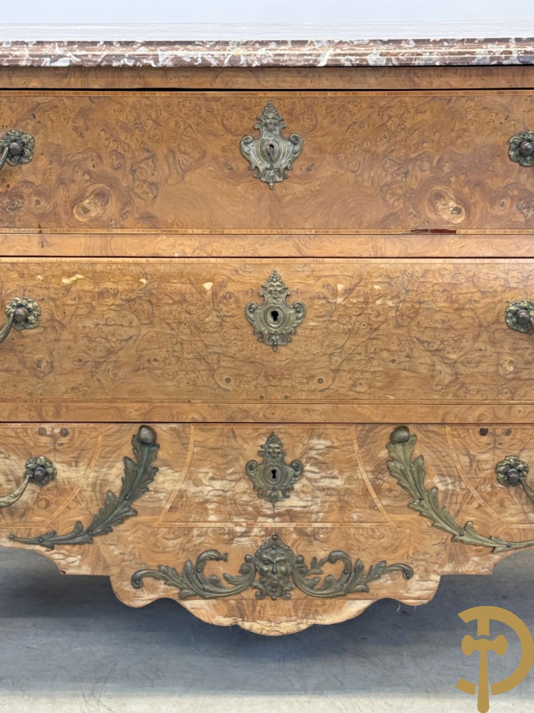 Wortelnotehouten drieladencommode met bronsbeslag van mazarinkoppen en accanthusranken, bovenaan met rood geaderd marmeren blad