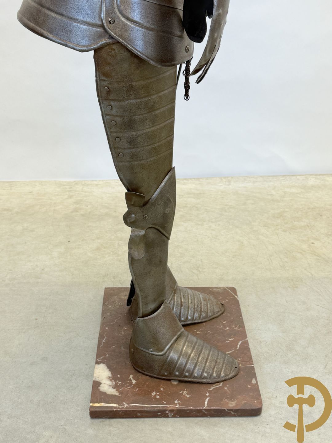 Decoratief plaatstalen ridderharnas met zwaard op marmeren voet