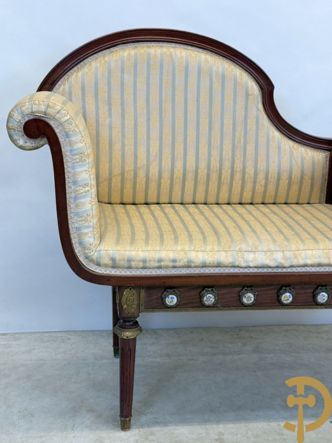 Banquette met ingebouwd bijzettafeltje bezet met porseleinen plakkettes op gecanneleerde poten